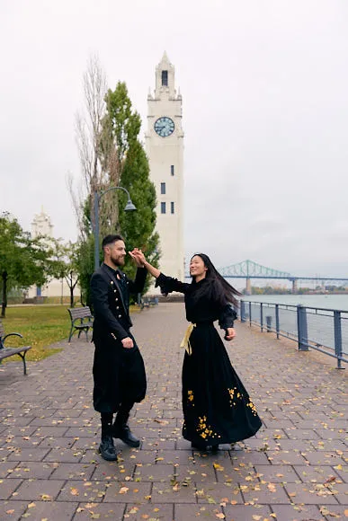 Couple vêtu de noir posant près de la tour de l'Horloge, dans le Vieux-Port de Montréal