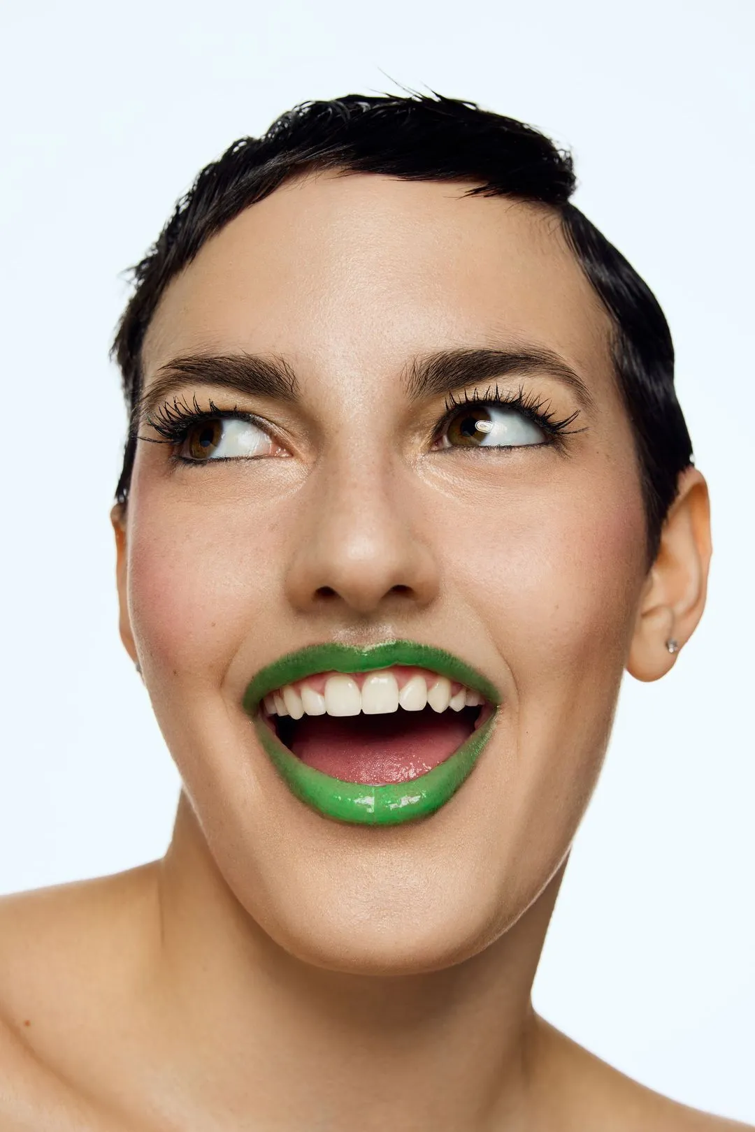 Portrait beauté ludique d'une mannequin au rouge à lèvres vert, le regard de côté
