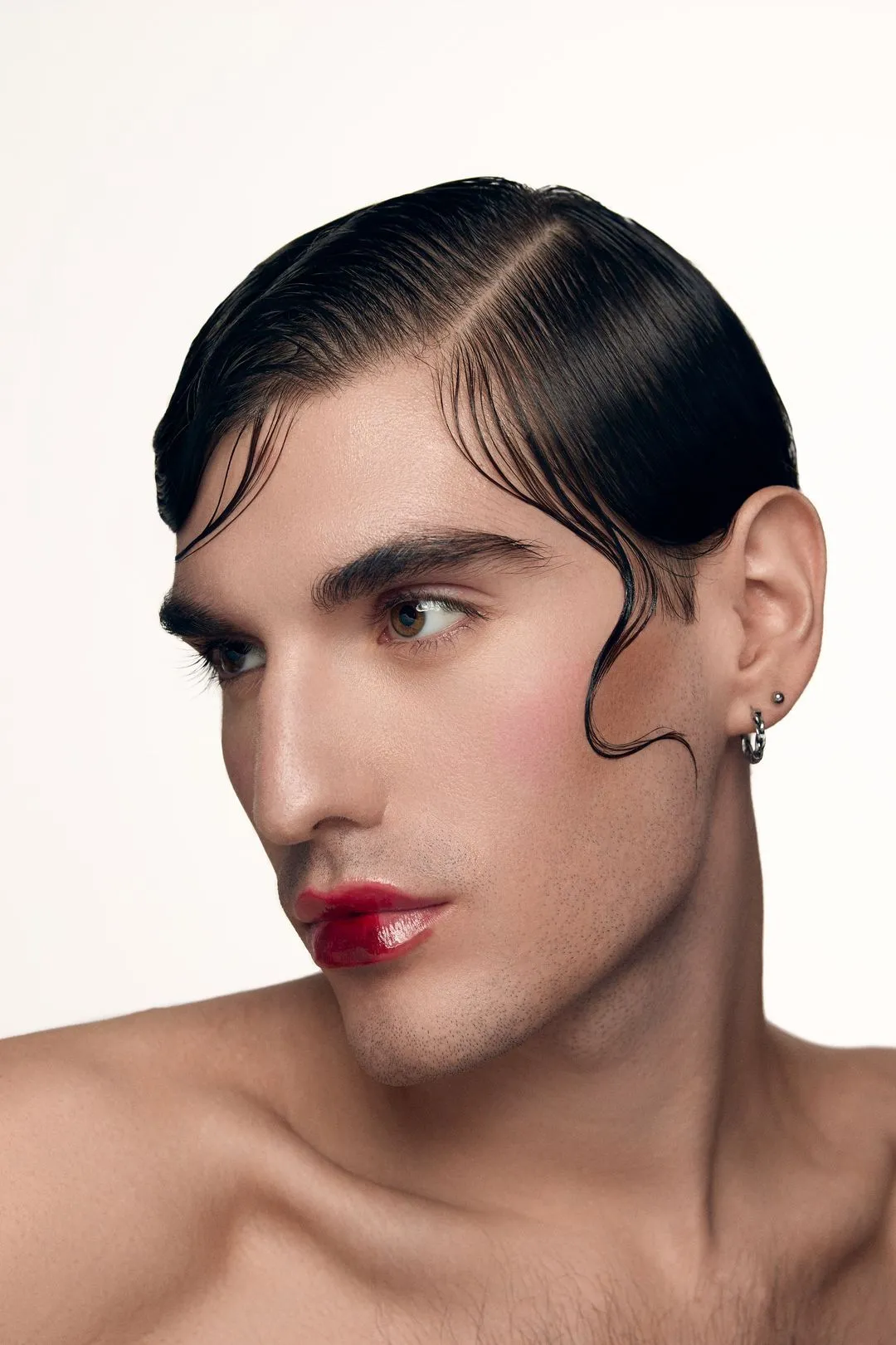 Portrait studio d'un mannequin aux cheveux sculptés effet mouillé et aux lèvres rouges brillantes