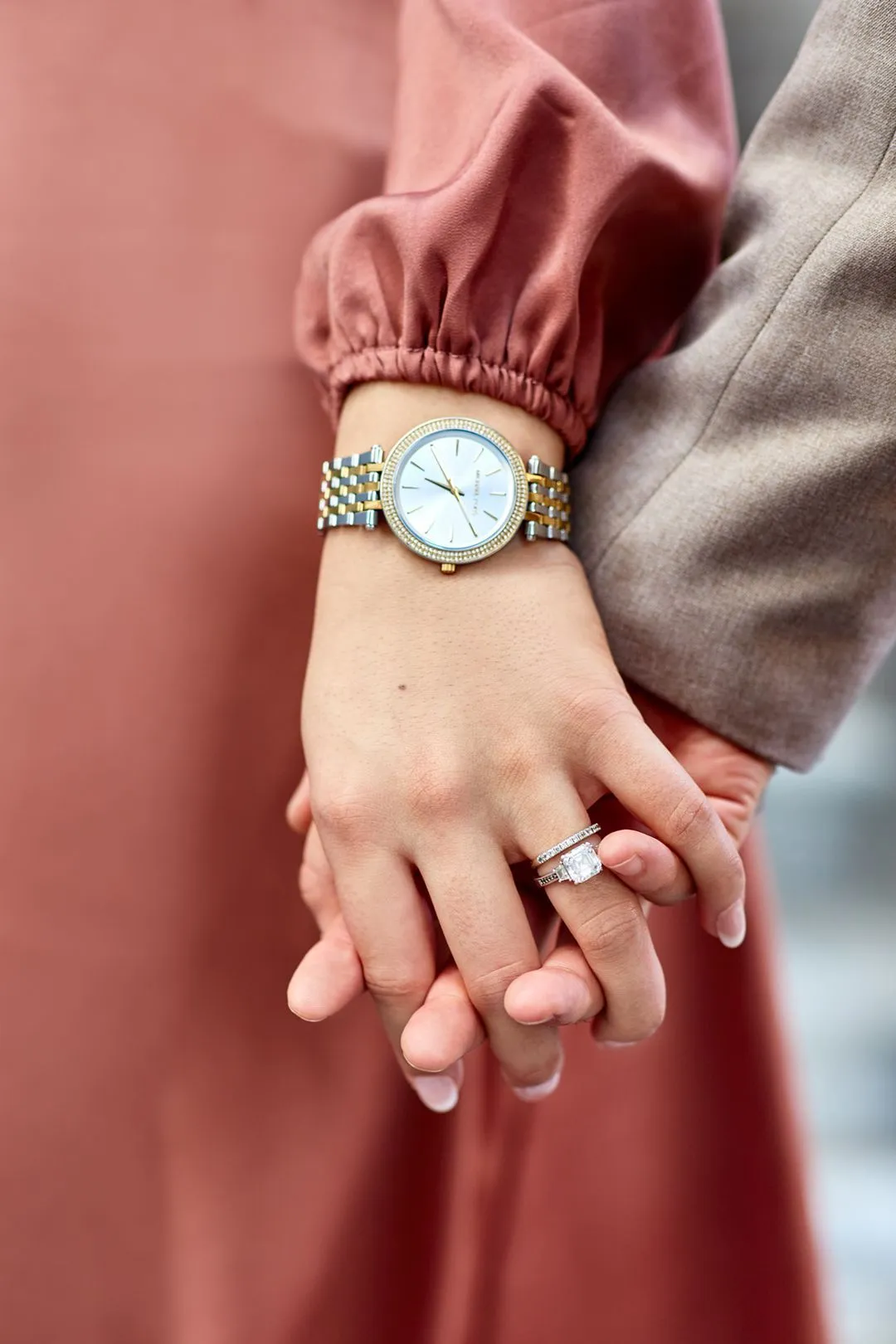 Gros plan de la main d'une femme portant sa bague de fiançailles, tenant la main de son partenaire
