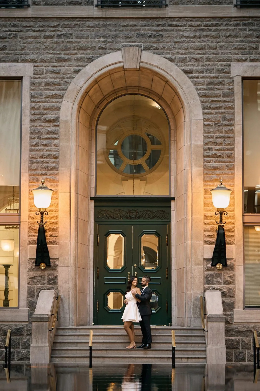 Couple debout dans l'entrée voûtée d'un édifice de pierre historique du Vieux-Montréal