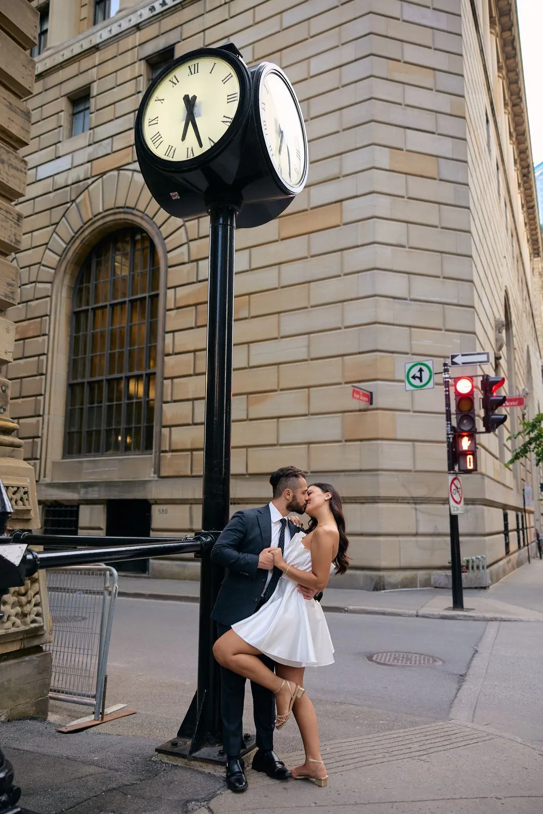 Couple s'embrassant sous une horloge de rue ancienne, à un coin de rue du Vieux-Montréal