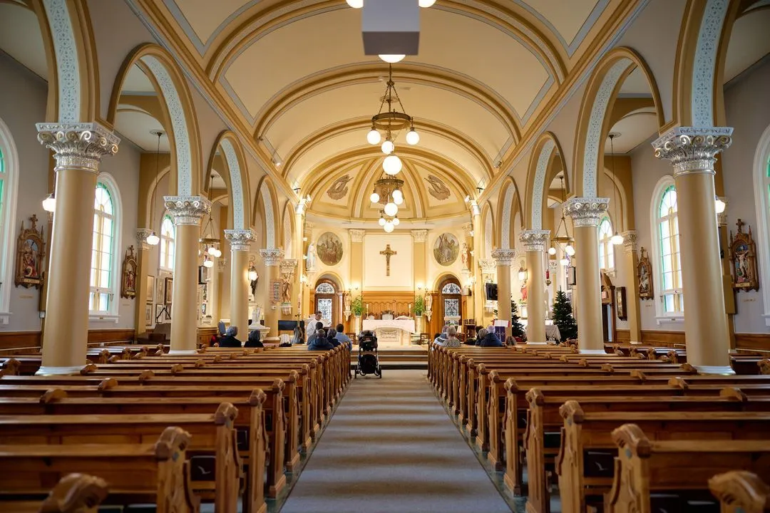Intérieur lumineux d'une église avec voûte en arc et bancs de bois avant un baptême