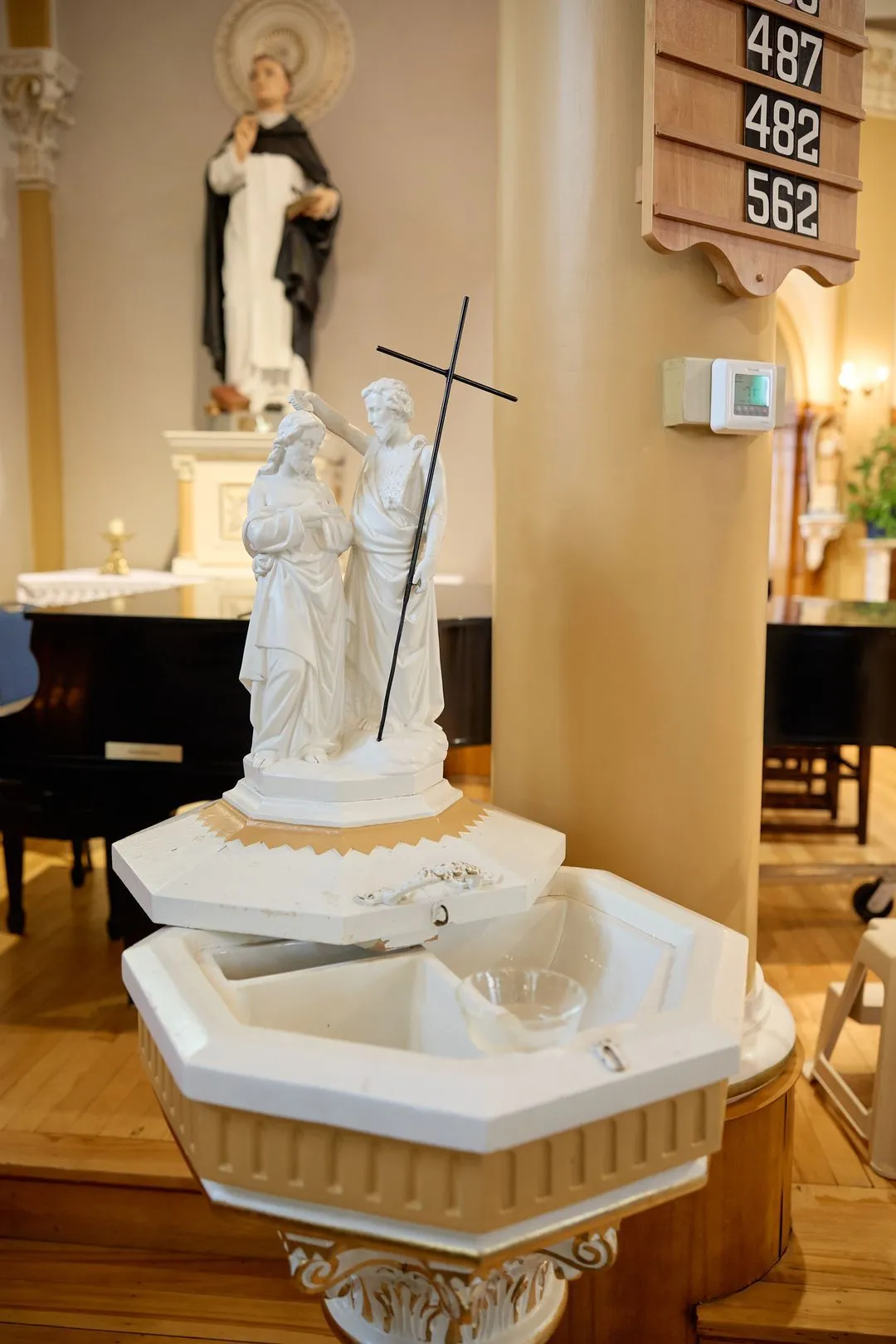 Fonts baptismaux surmontés d'une statue du baptême du Christ, dans l'église