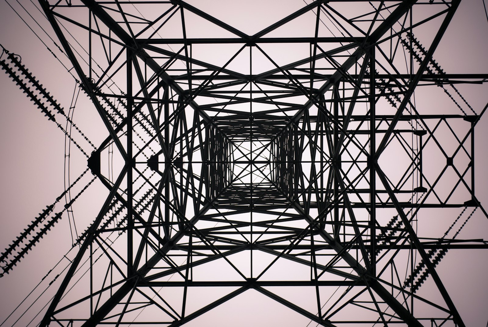 UK electricity transmission pylon under cloudy sky, photograph by Shane Rounce on Unsplash
