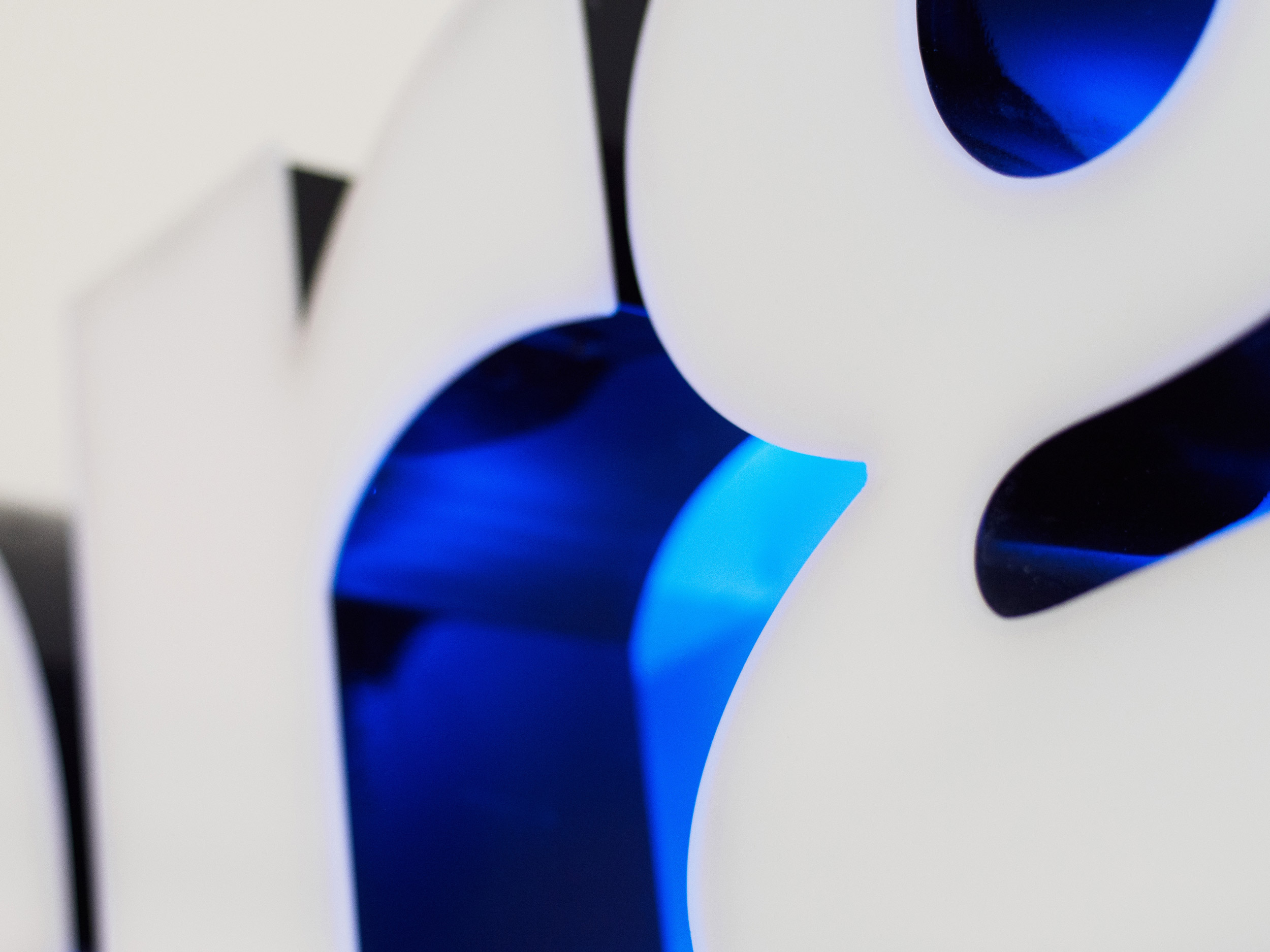 Närbild av vita 3D-siffror med blått ljus som lyser genom ett mellanrum.