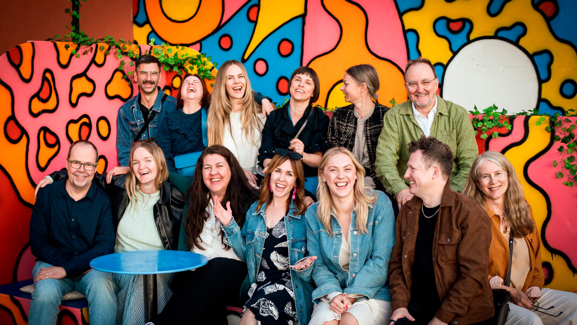 Teamet Appelberg är glada mot en färgglad bakgrund.