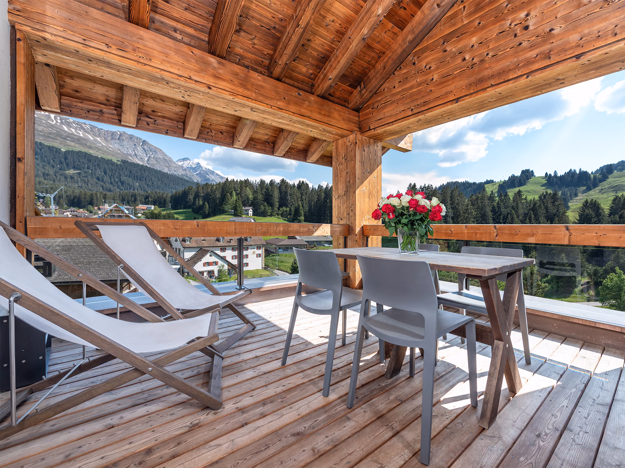 Aussicht auf Berge, grüne Bergwiesen und Wälder vom Balkon einer der Turrabuel Ferienwohnungen in Lenzerheide