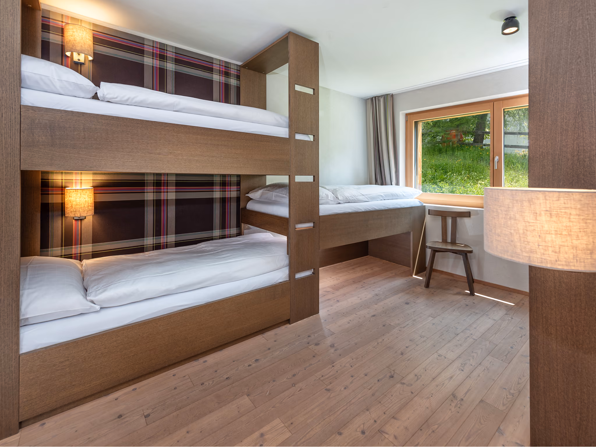 Die Etagenbetten in einem Kinderzimmer unserer Family Deluxe Ferienwohnungen im Sommer. Perfekt für Ihren Familien-Sommerurlaub in Lenzerheide.