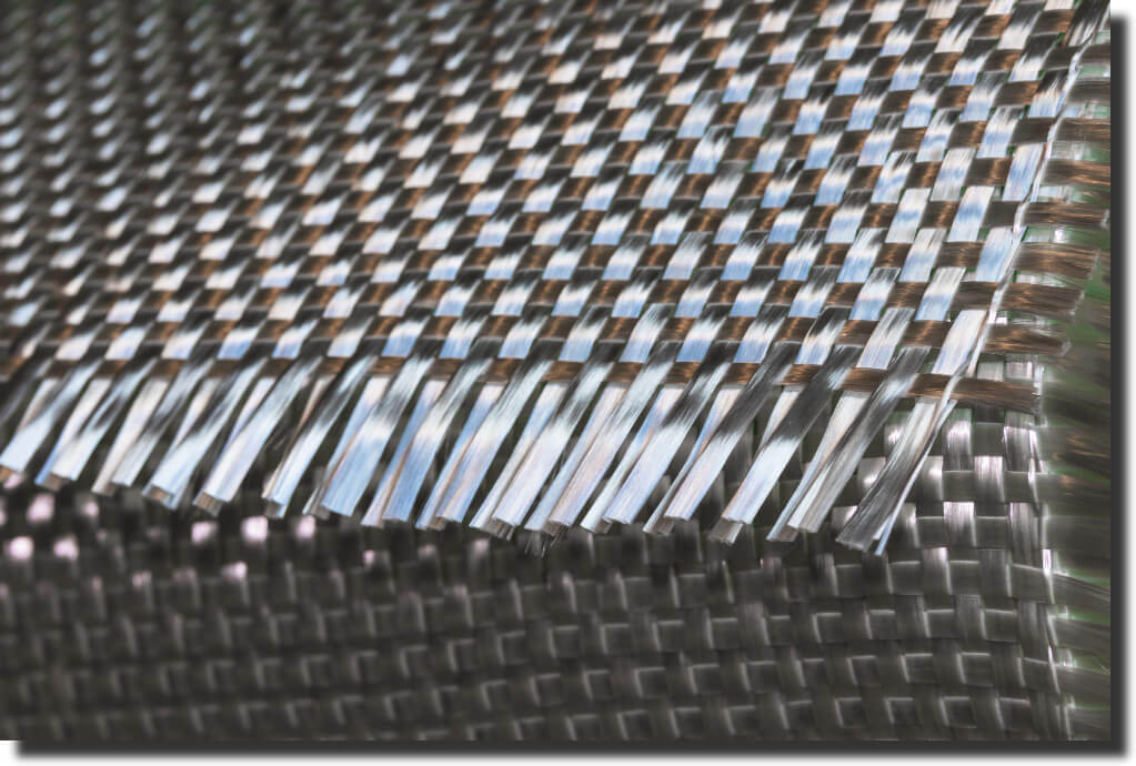 Macro of tightly woven carbon‑fiber cloth highlighting lightweight twill strands and the difference between fiberglass and carbon fiber fabrics.