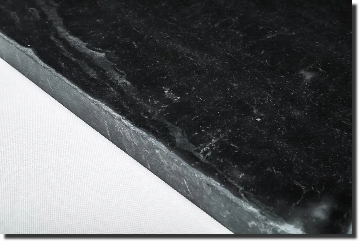 Close-up of marbled forged carbon fiber plate, illustrating the chopped-tow texture of forged composite parts.