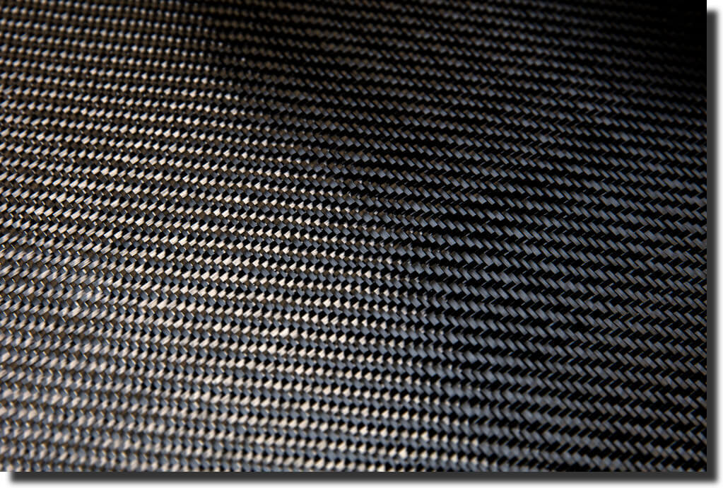 Tight close-up of woven carbon fiber, highlighting weave depth used to tell real carbon fiber from fake printed patterns