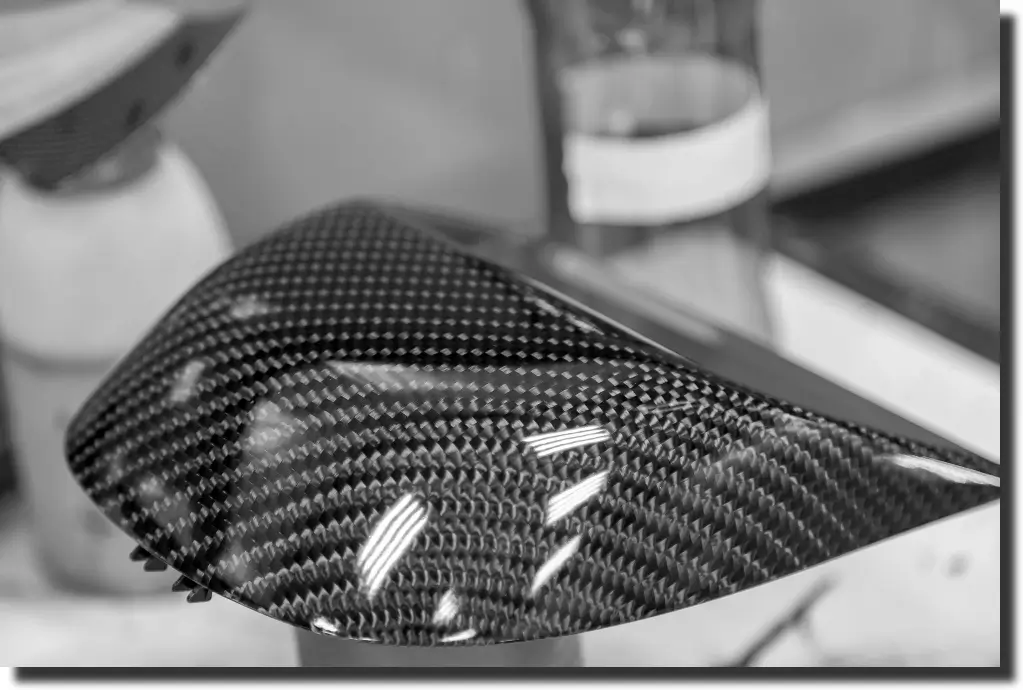 Glossy carbon fiber part illustrating carbon fiber tensile strength, fiber orientation, and structural behavior under load.
