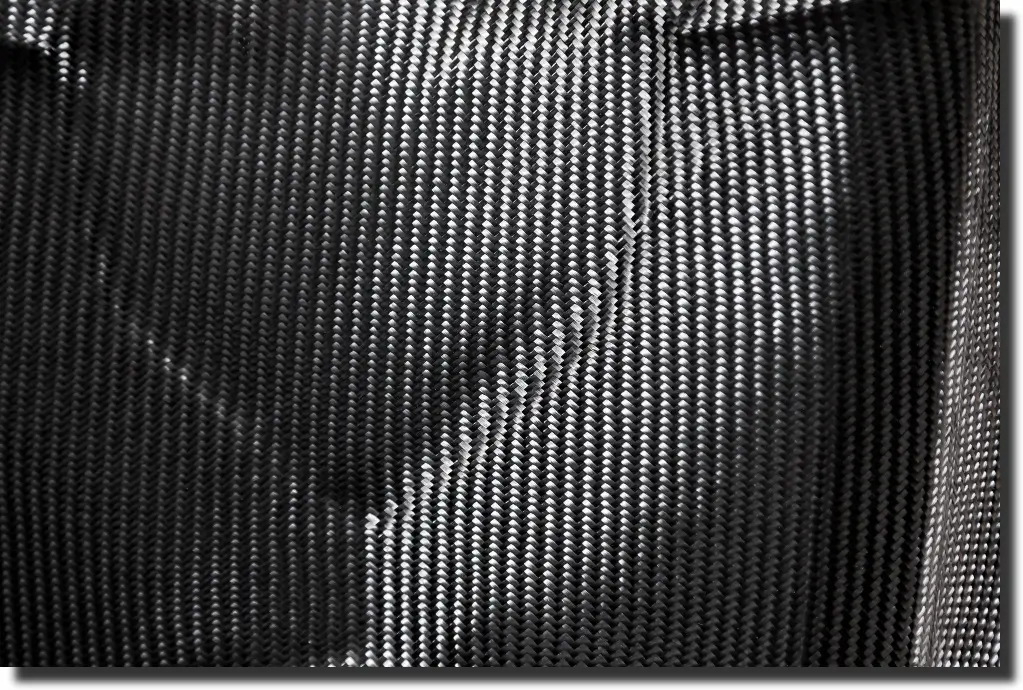 Close-up of woven carbon fiber texture, illustrating how strong is carbon fiber when fibers follow the main load path.