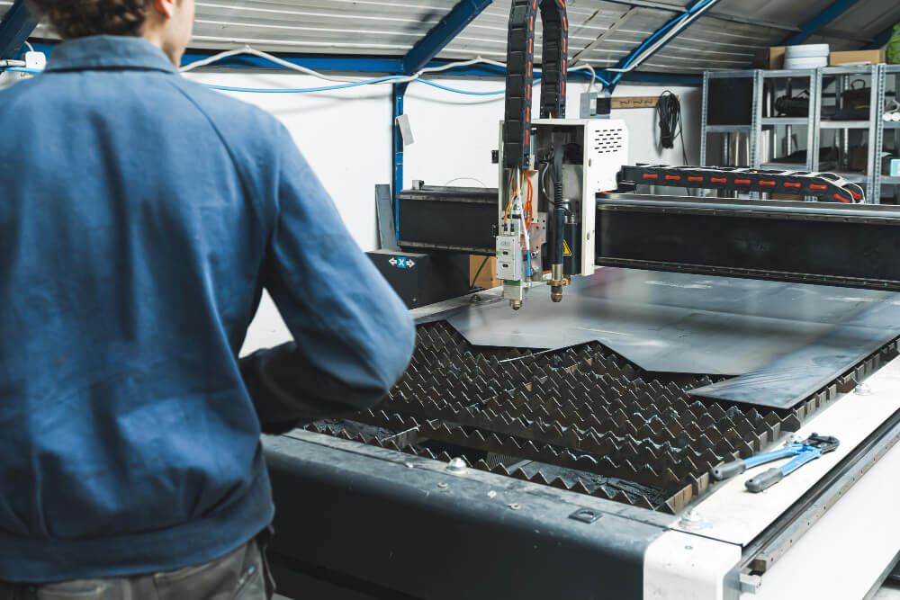 Technician operating CNC equipment for machining carbon fiber parts with clean edges and tight tolerances