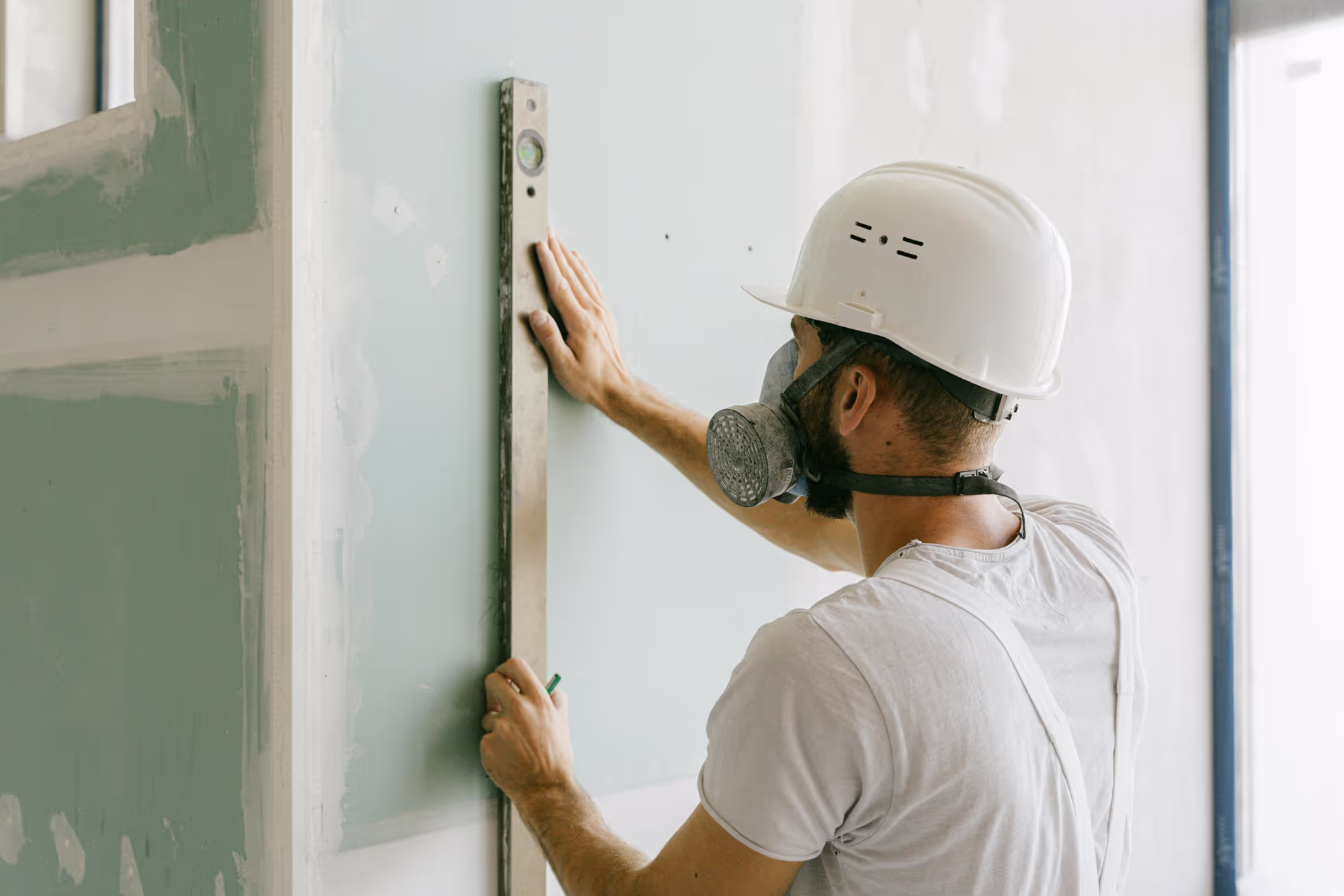 Photo of a construction worker smoothing plaster on a wall
