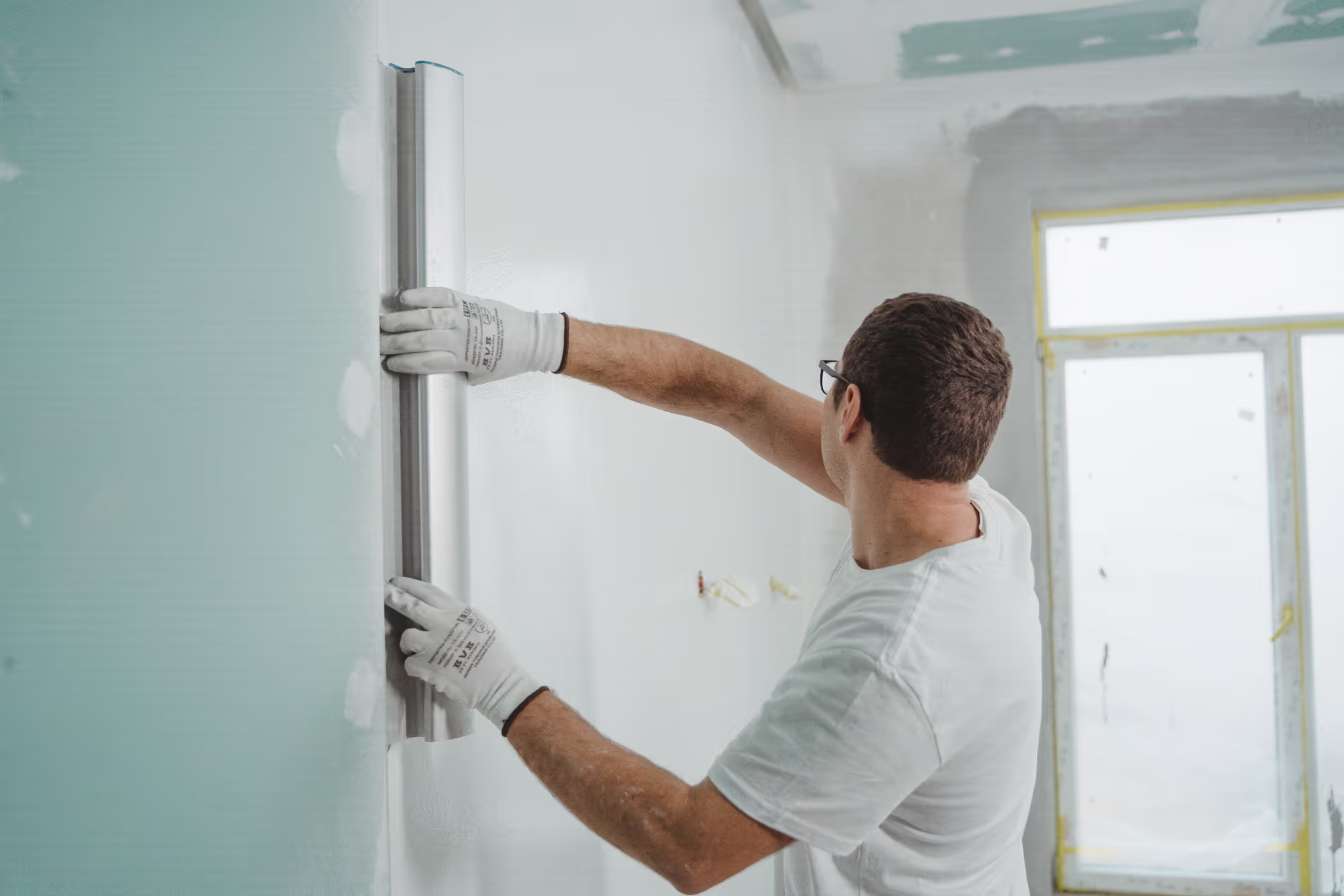Photo of a worker measuring a wall with a level