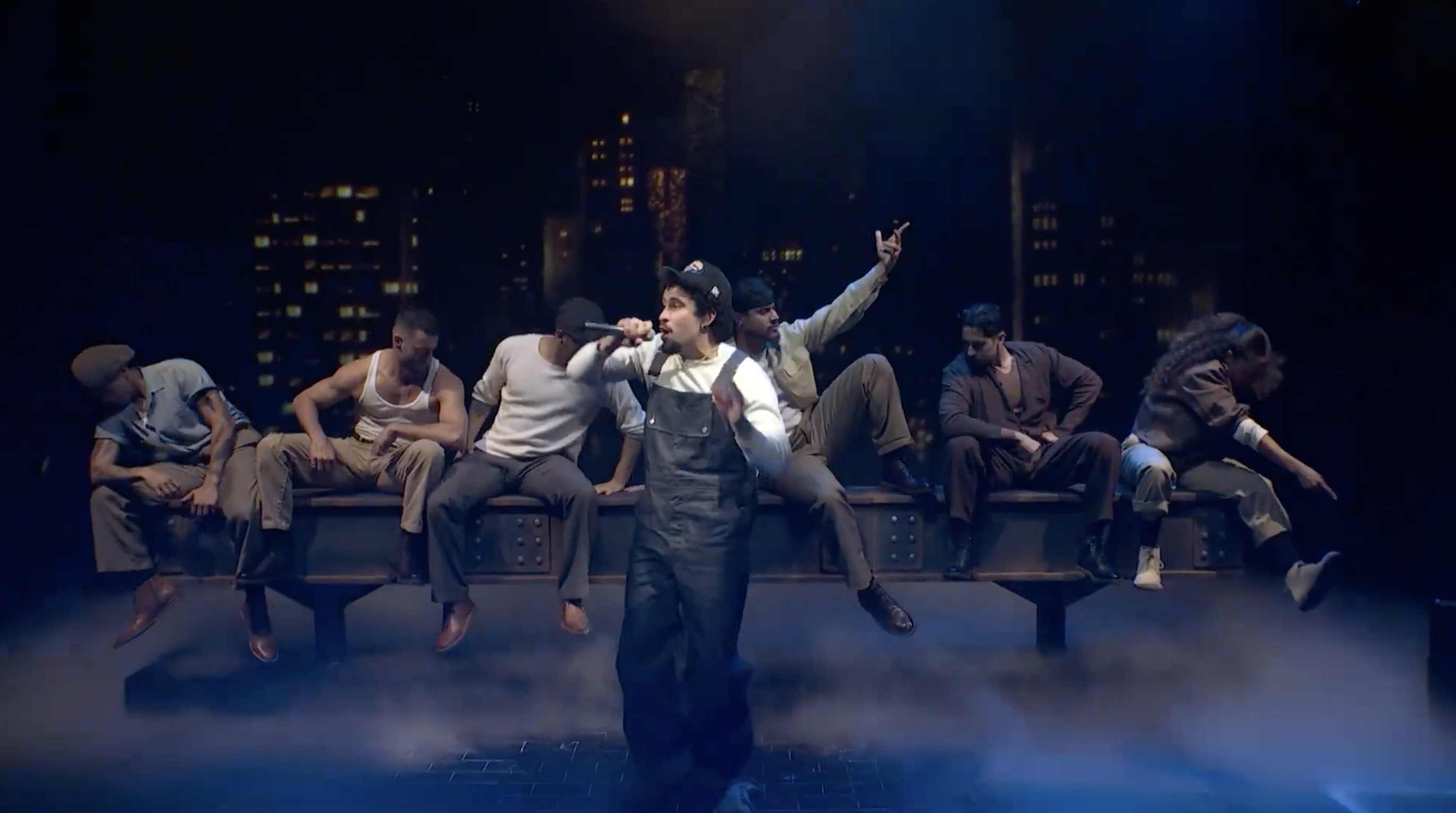 Musical performers on stage with city skyline, singing and dancing dynamically