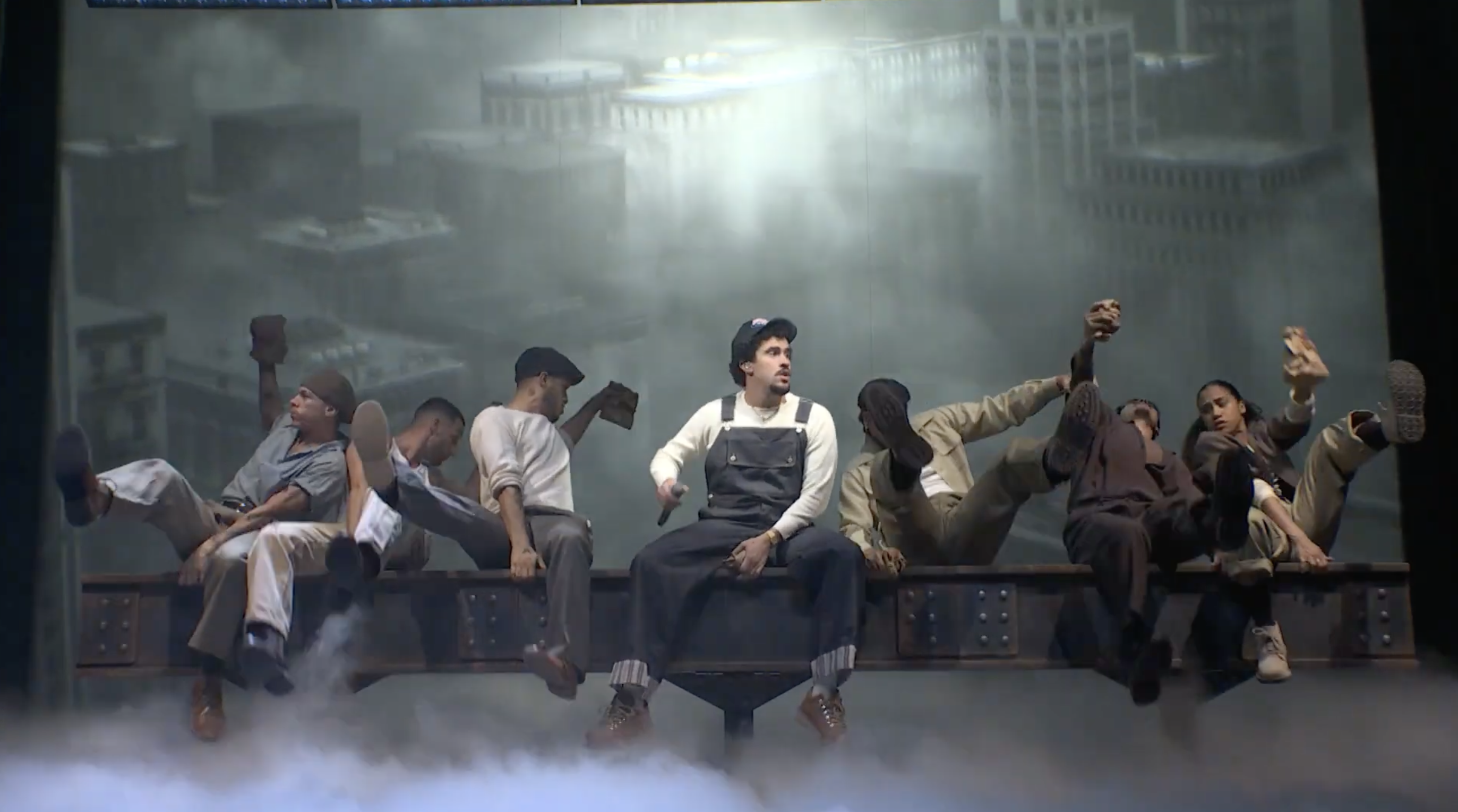 Workers sitting on steel beam high above misty cityscape during construction