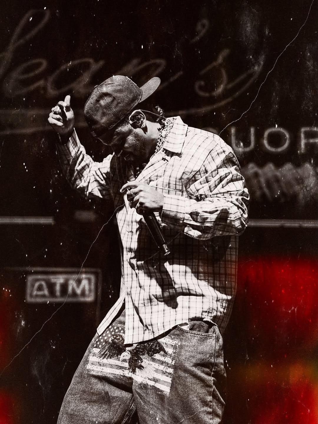 Performer in plaid shirt singing passionately with microphone on stage