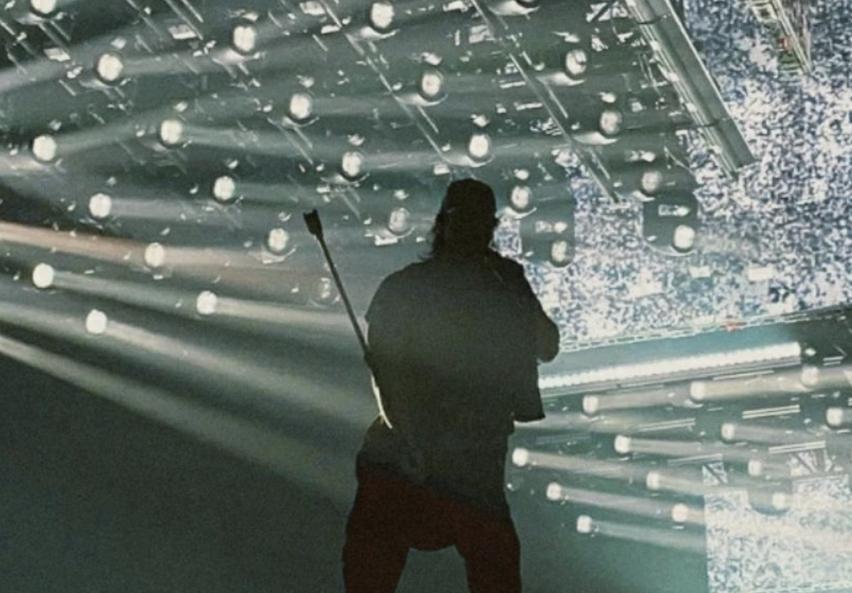 Silhouette standing in rain with water droplets on glass surface