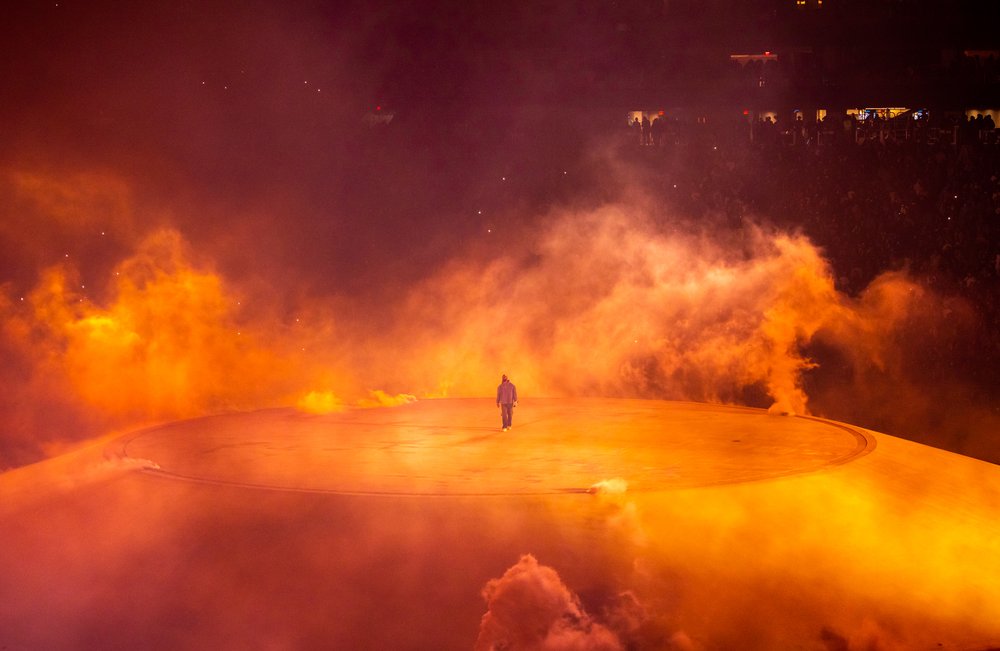 Lone figure surrounded by intense orange smoke and fiery clouds