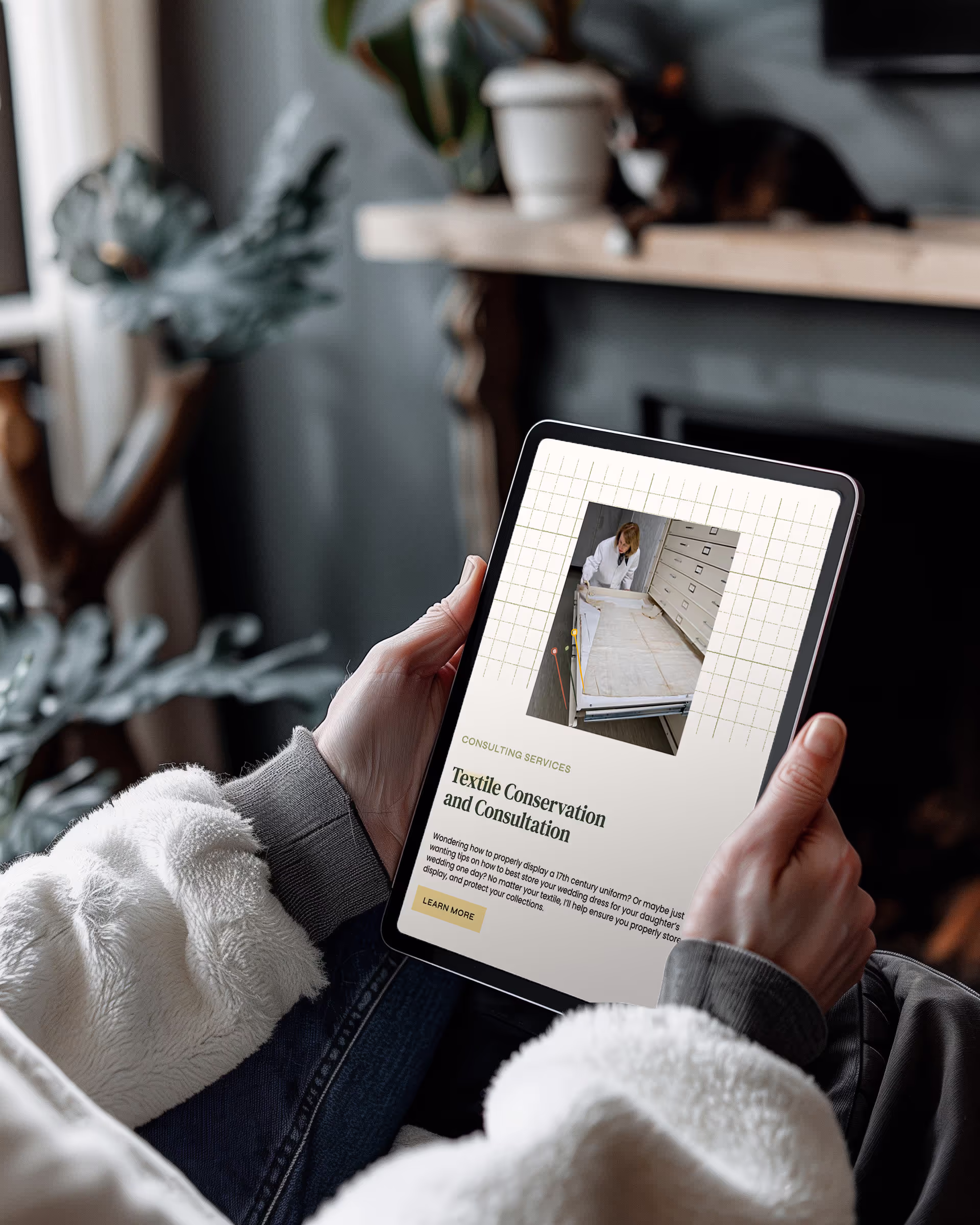 A person holding a tablet with the website for Julie's Sewing Room displayed on the screen. This website is created by EQBM Design Company.