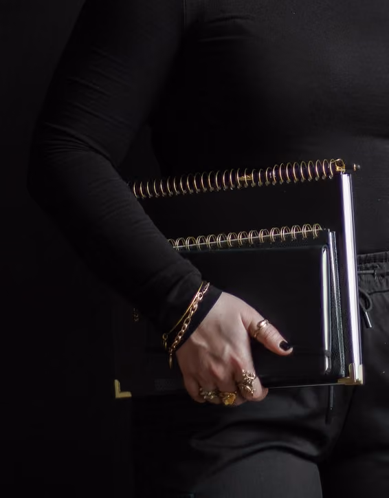 Hannah Hernandez holding a couple of notebooks.