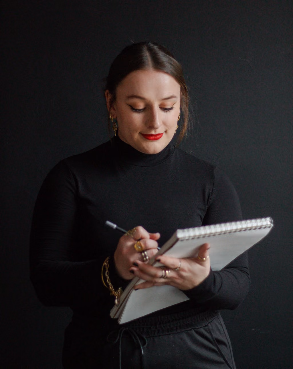 Hannah Hernandez, founder and creative director for EQBM Design Company, sketching ideas for a brand in a sketchbook.