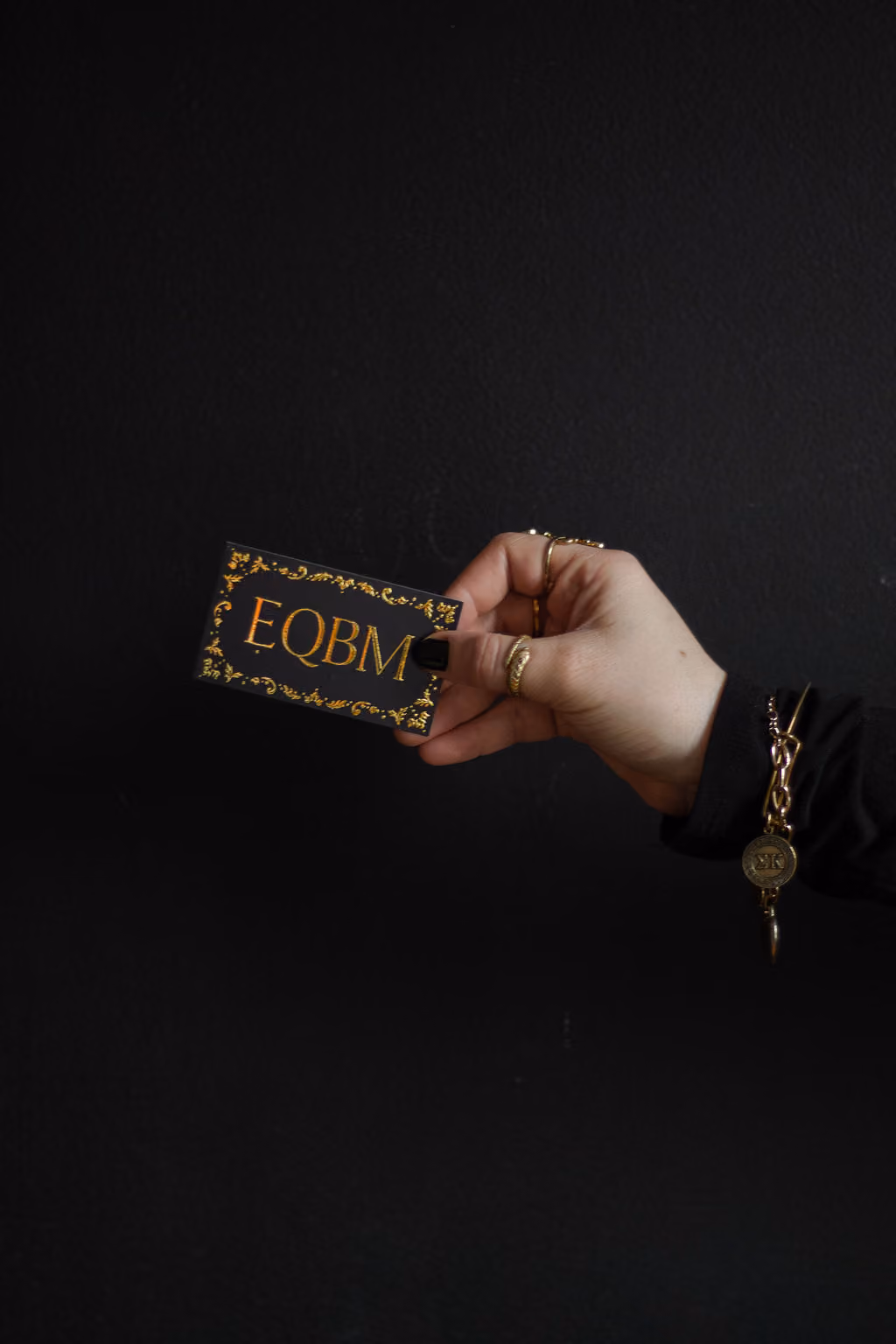 Hannah Hernandez holding a business card for EQBM.