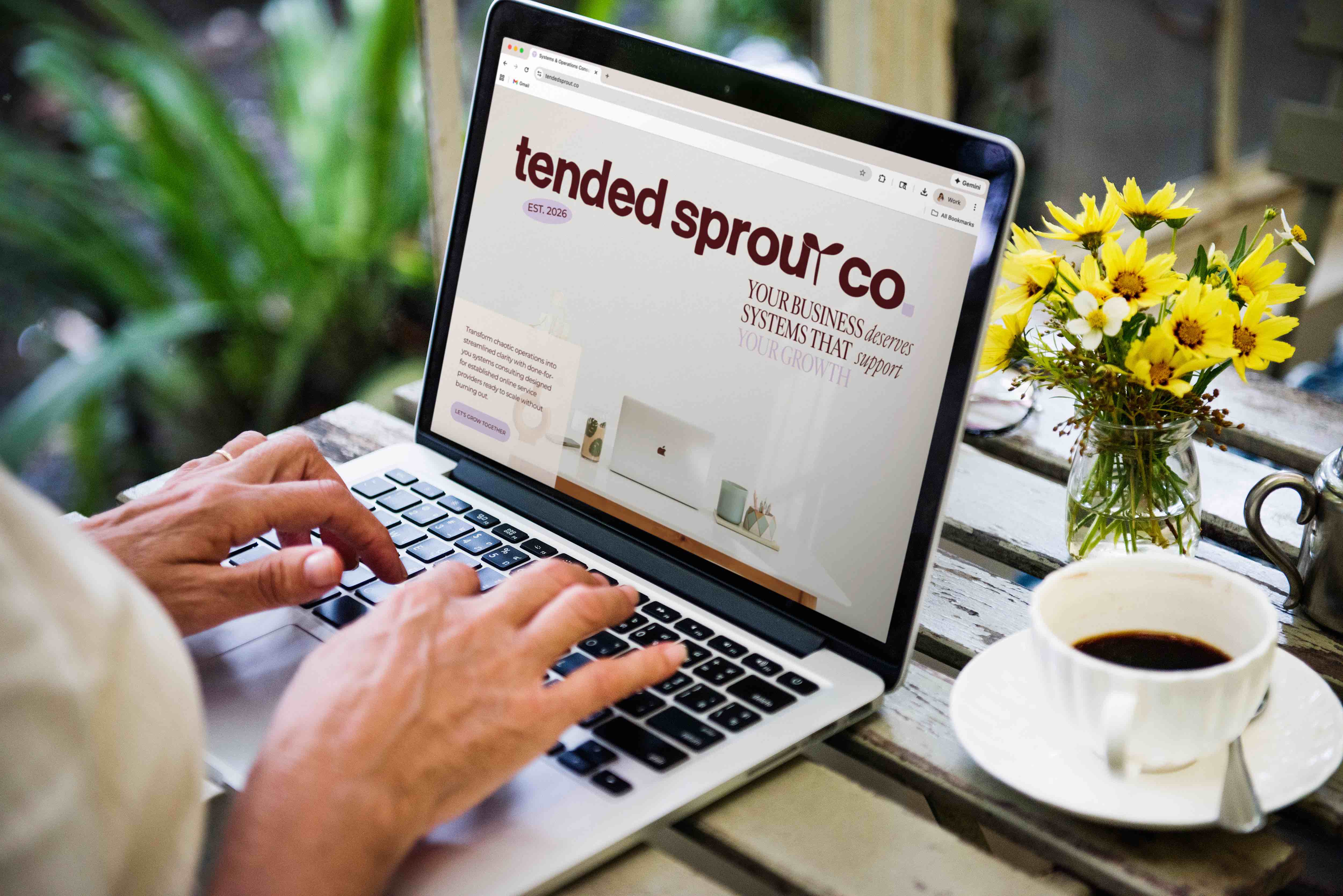 A woman typing on a laptop at an outdoor table. She has the website for Tended Sprout Co open in her web browser, designed by EQBM Design Company.