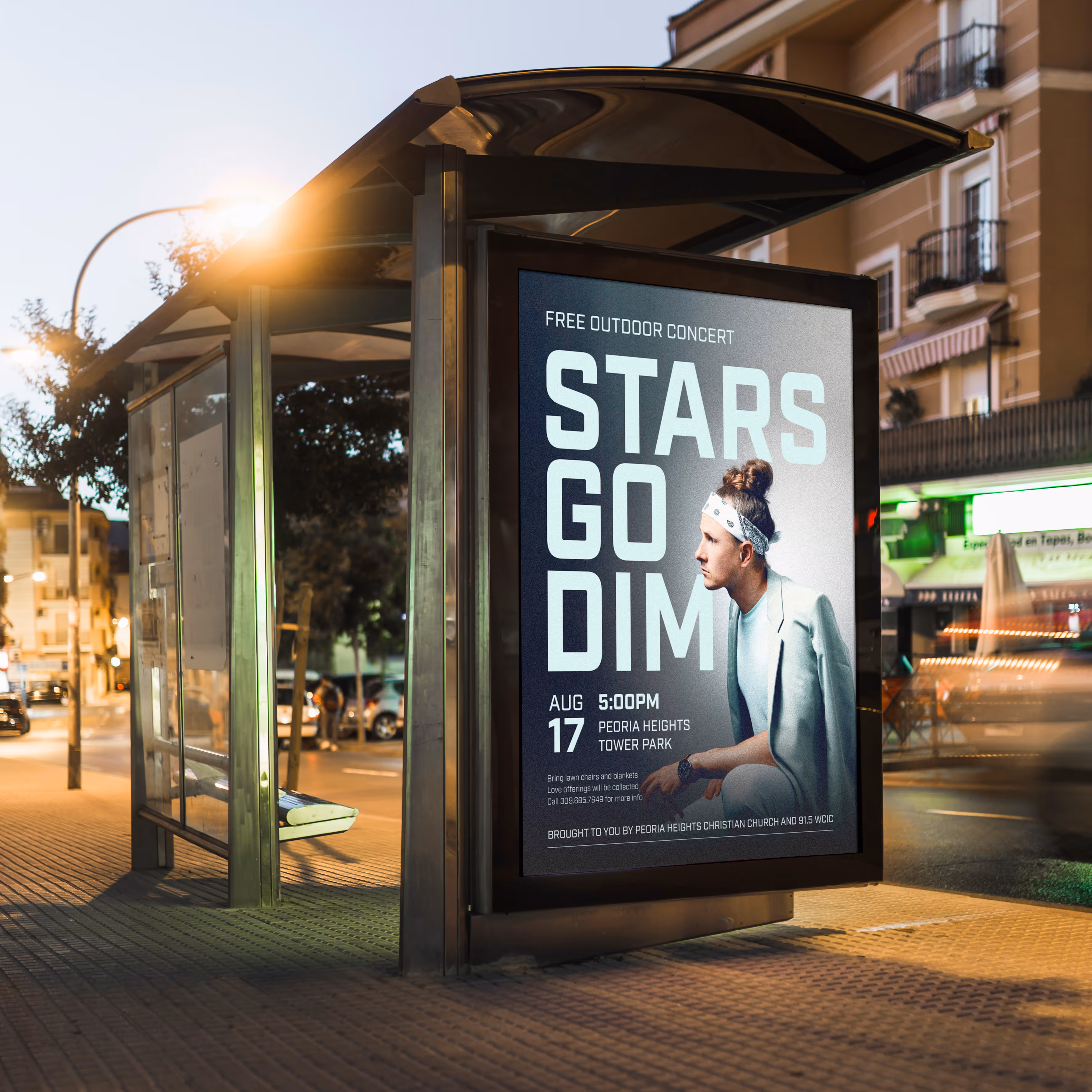 A bus stop with a large advertisement for a free outdoor concert designed by EQBM Design Company.