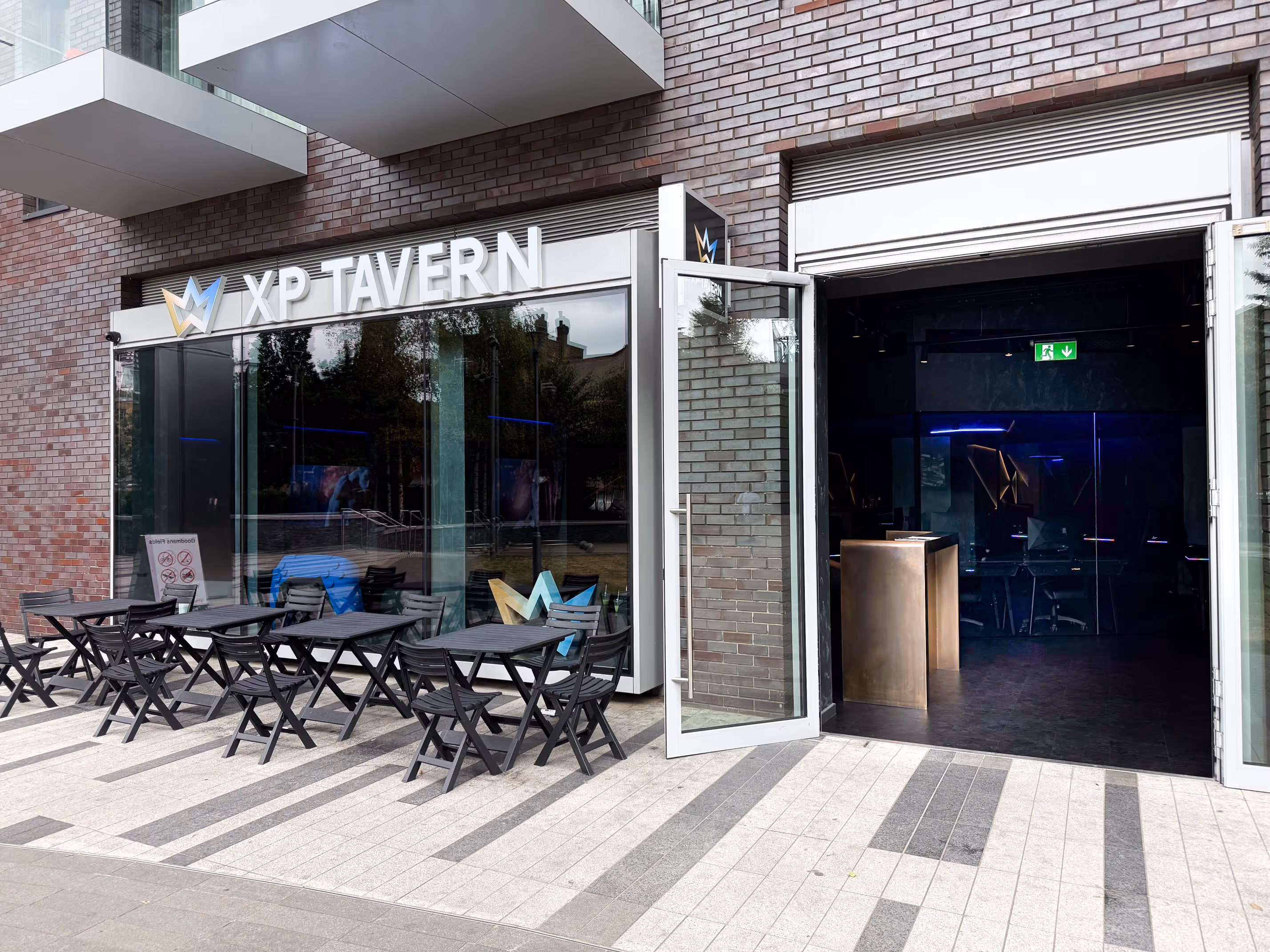 Modern gaming-themed bar featuring a glowing game controller decoration, elegant bar seating, and ambient lighting creating a cozy atmosphere.