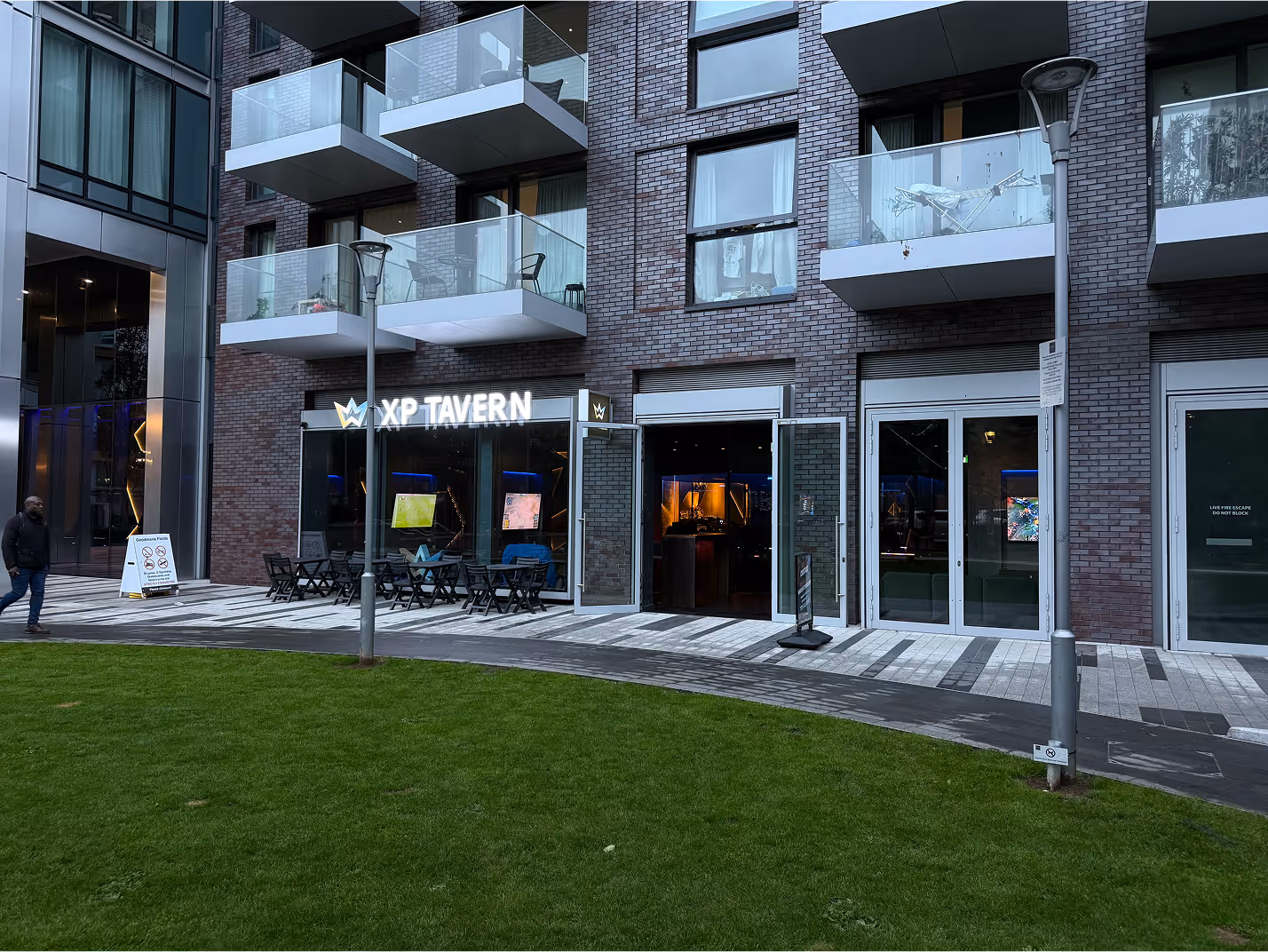 Modern gaming-themed bar featuring a glowing game controller decoration, elegant bar seating, and ambient lighting creating a cozy atmosphere.