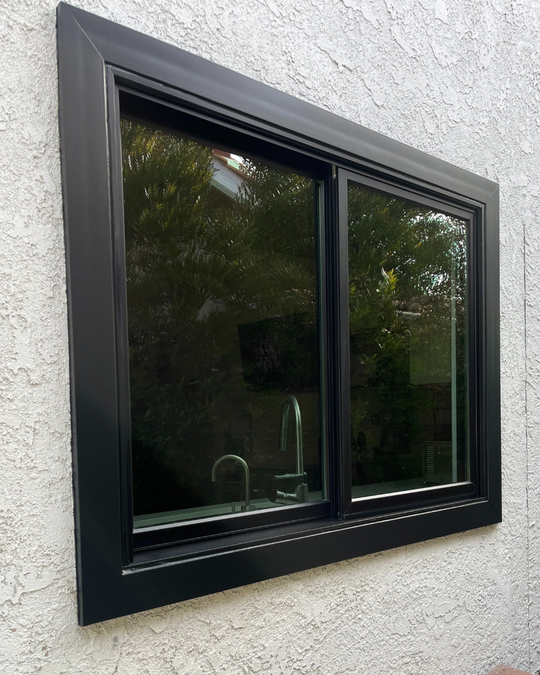 After: Exterior view of new sliding window with black frames