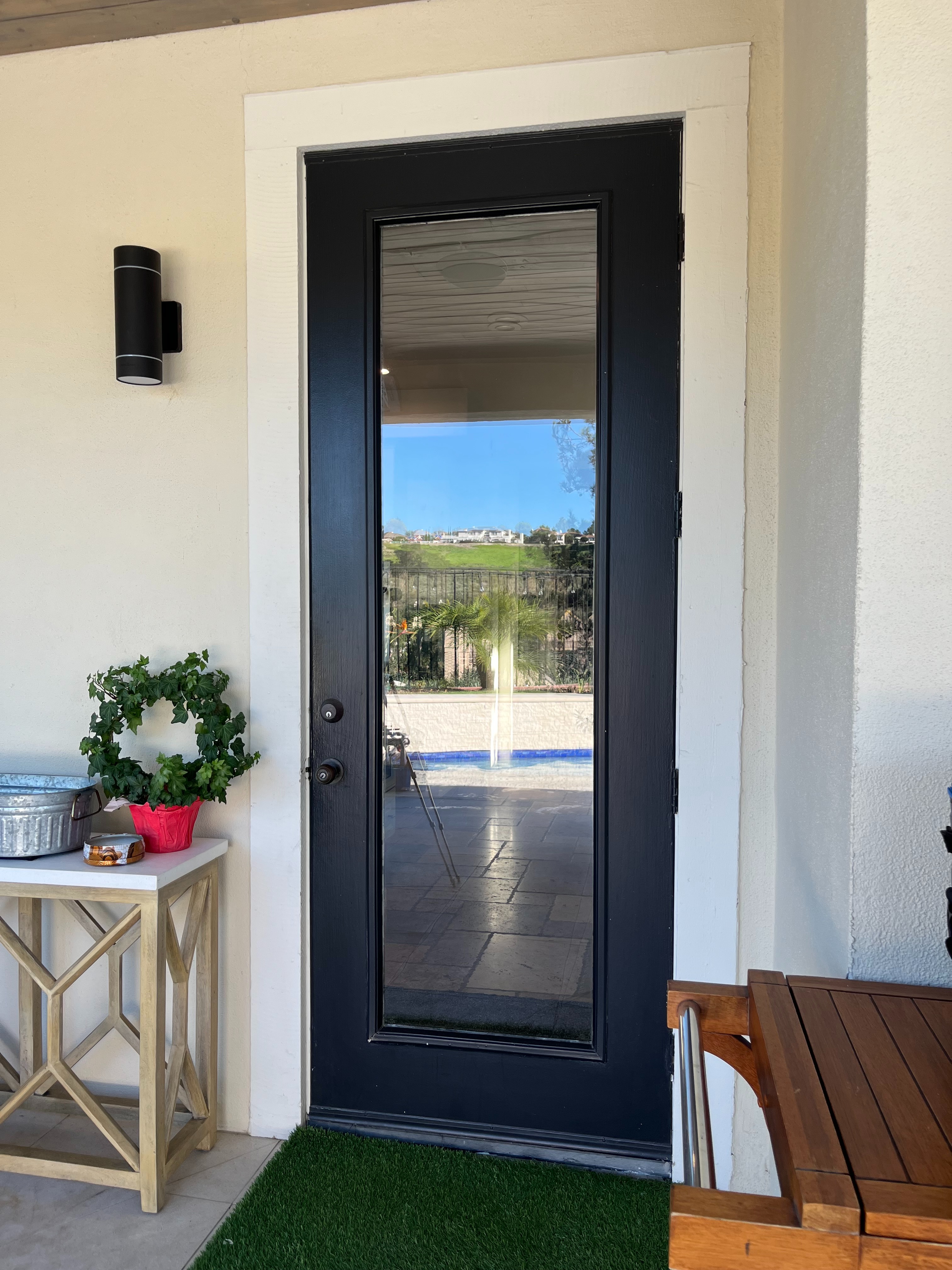Before: exterior view of an outdated black patio door with standard hardware.