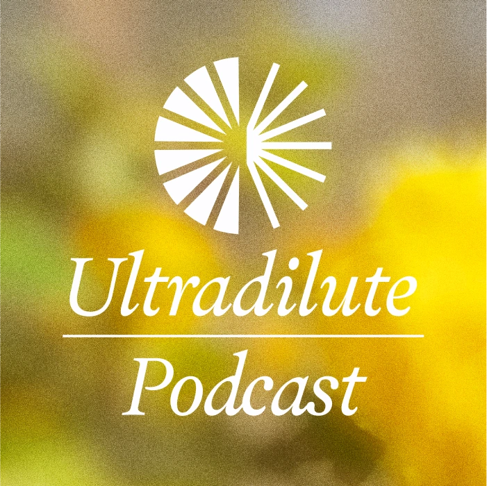 A square logo for the "Ultradilute Podcast" features white serif text and a stylized semi-circular burst icon centered above the words, all set against a softly blurred background of yellow and green with a light yellow border.