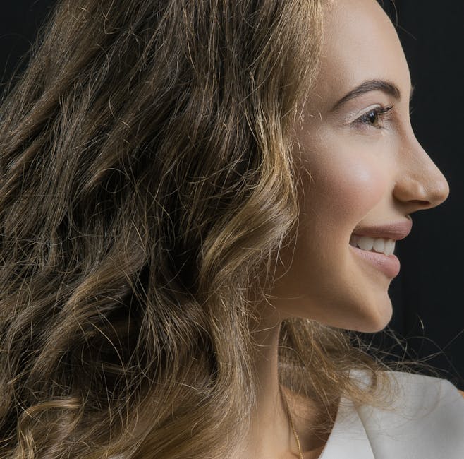 Close-up of a smiling woman with curly hair in profile view highlighting natural beauty.
