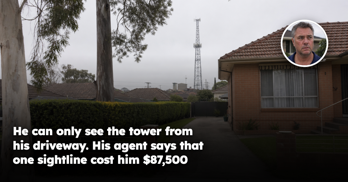 The driveway and front yard of an ordinary Australian suburban house, with a steel lattice mobile phone tower visible in the distance above the neighbouring rooflines against a grey sky.