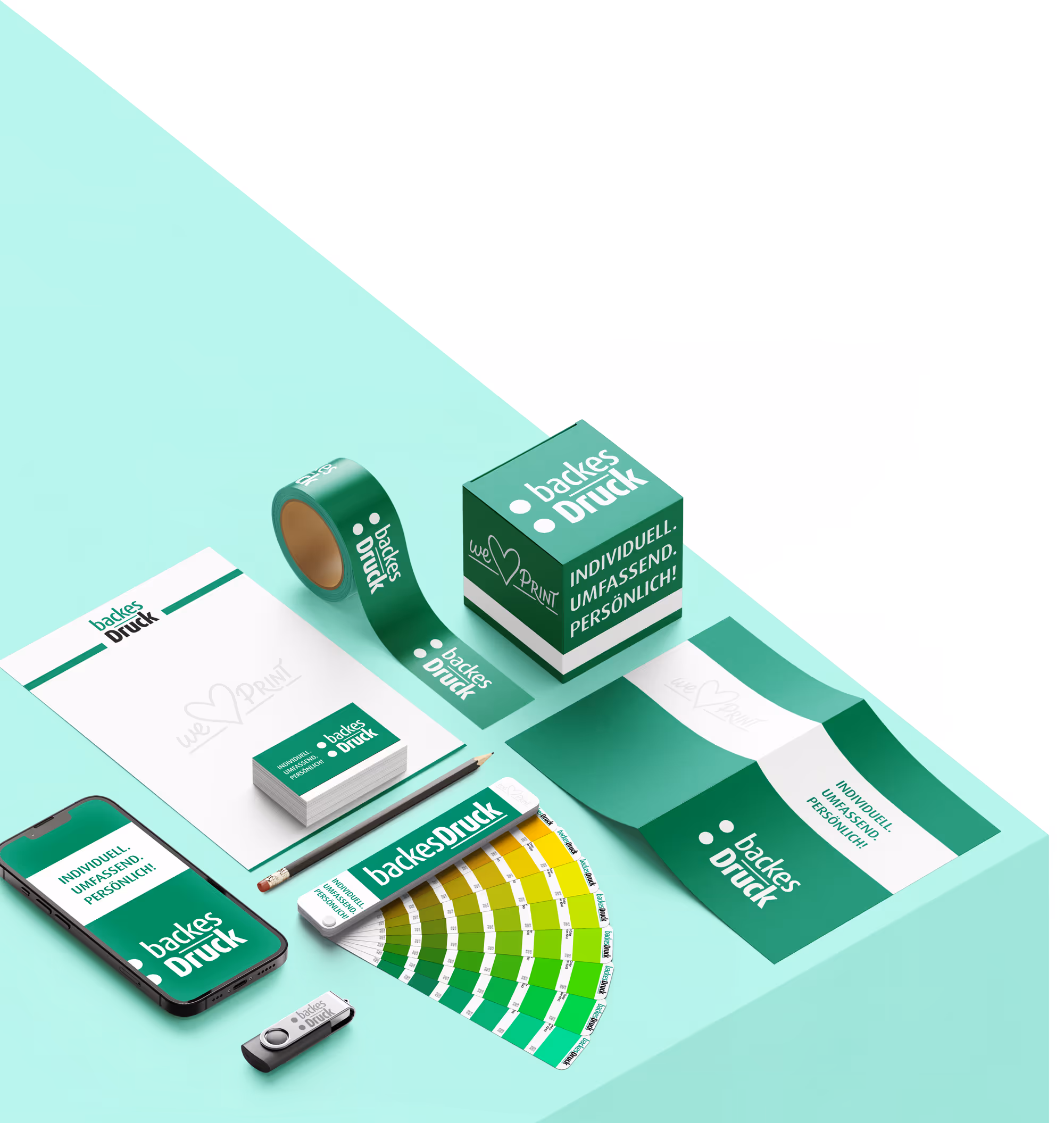 Hero-Darstellung des Grafik-Service von backesDruck: Layout-Entwürfe, Faltschachtel, Klebeband und Druckprodukte in Markenfarben Grün und Weiß mit dem Claim „Individuell. Umfassend. Persönlich.“ – Symbol für Gestaltung, Markendesign und präzise Druckvorbereitung aus Langenfeld.