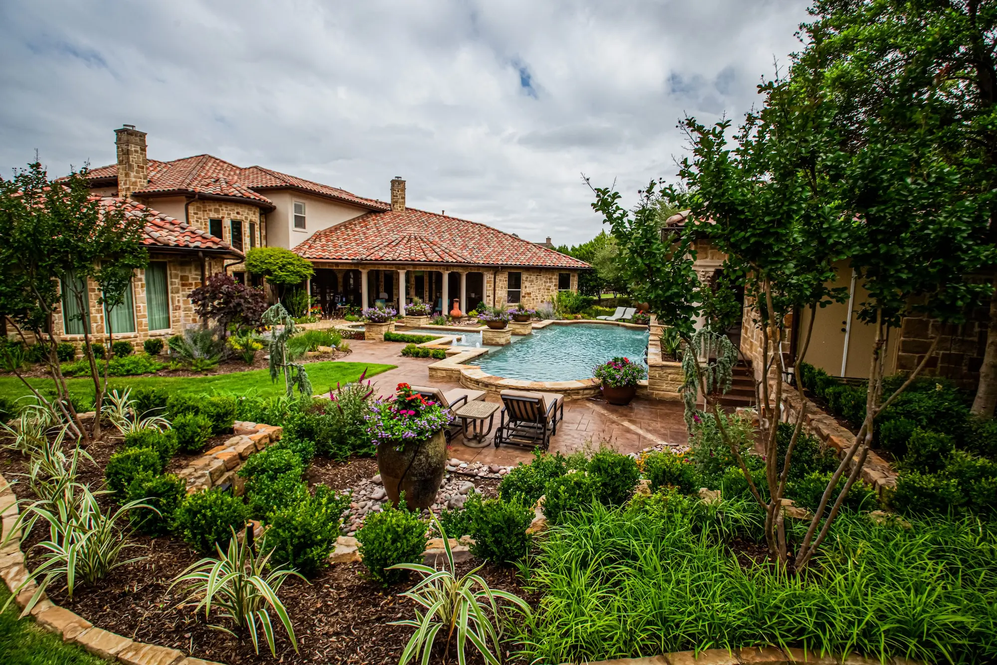 A serene backyard featuring a sparkling pool surrounded by a stylish patio perfect for relaxation and outdoor gatherings