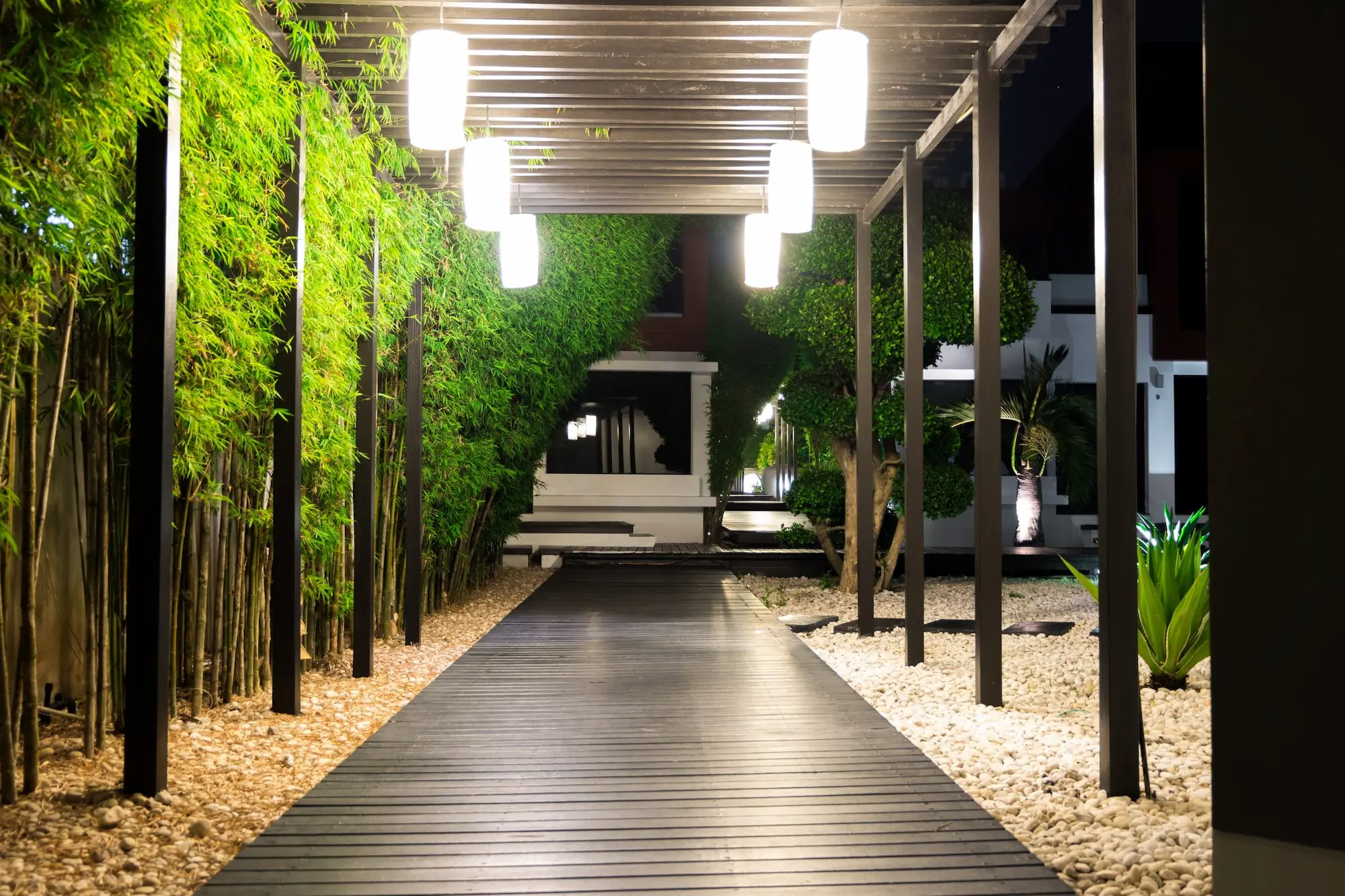 An illuminated walkway surrounded by vibrant plants, inviting evening strolls in a peaceful and enchanting setting
