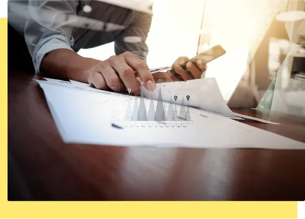 A businessman focused on paperwork while using a laptop, showcasing a professional work environment
