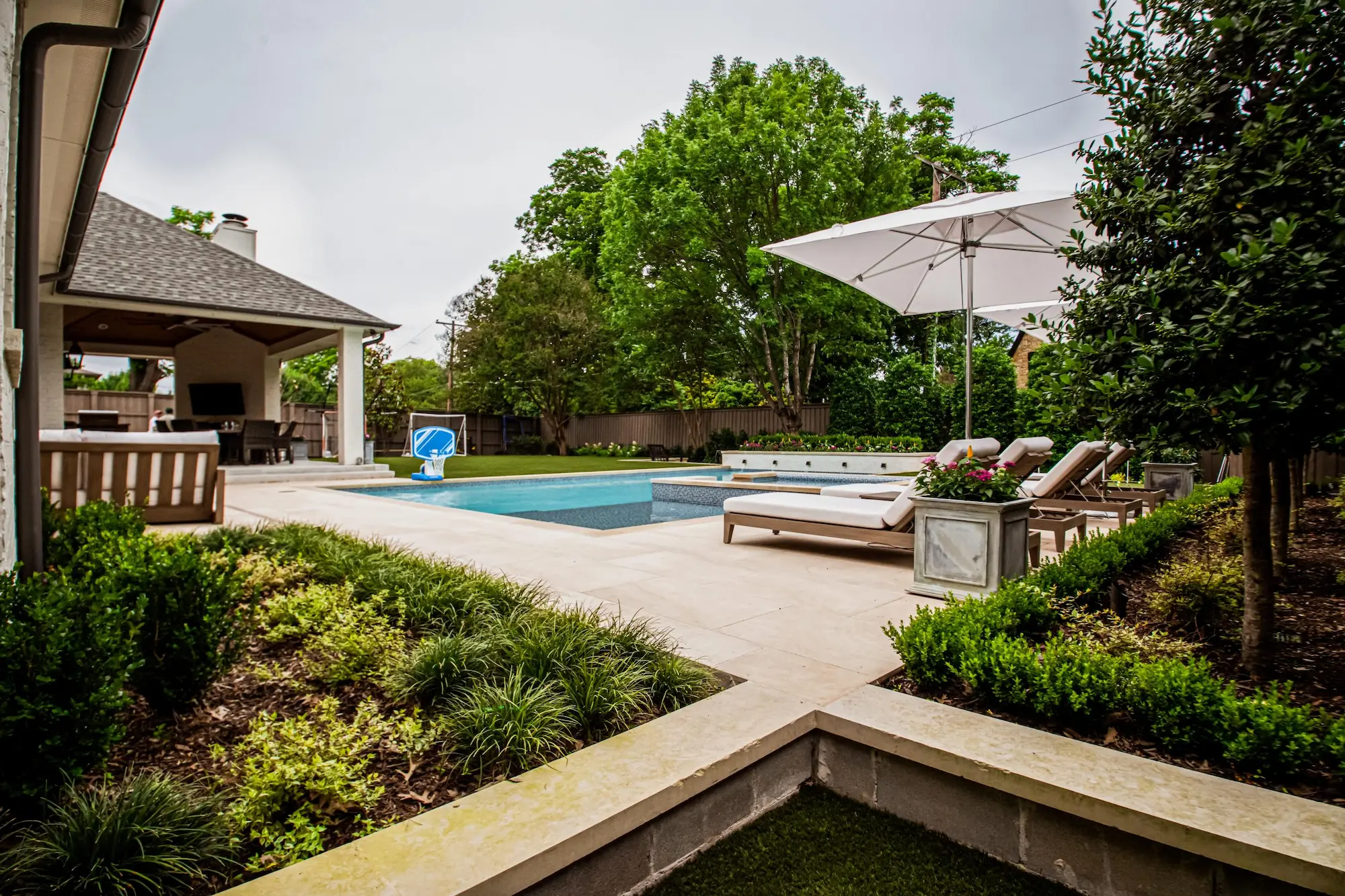 A serene backyard featuring a sparkling pool surrounded by comfortable patio furniture for relaxation and leisure.