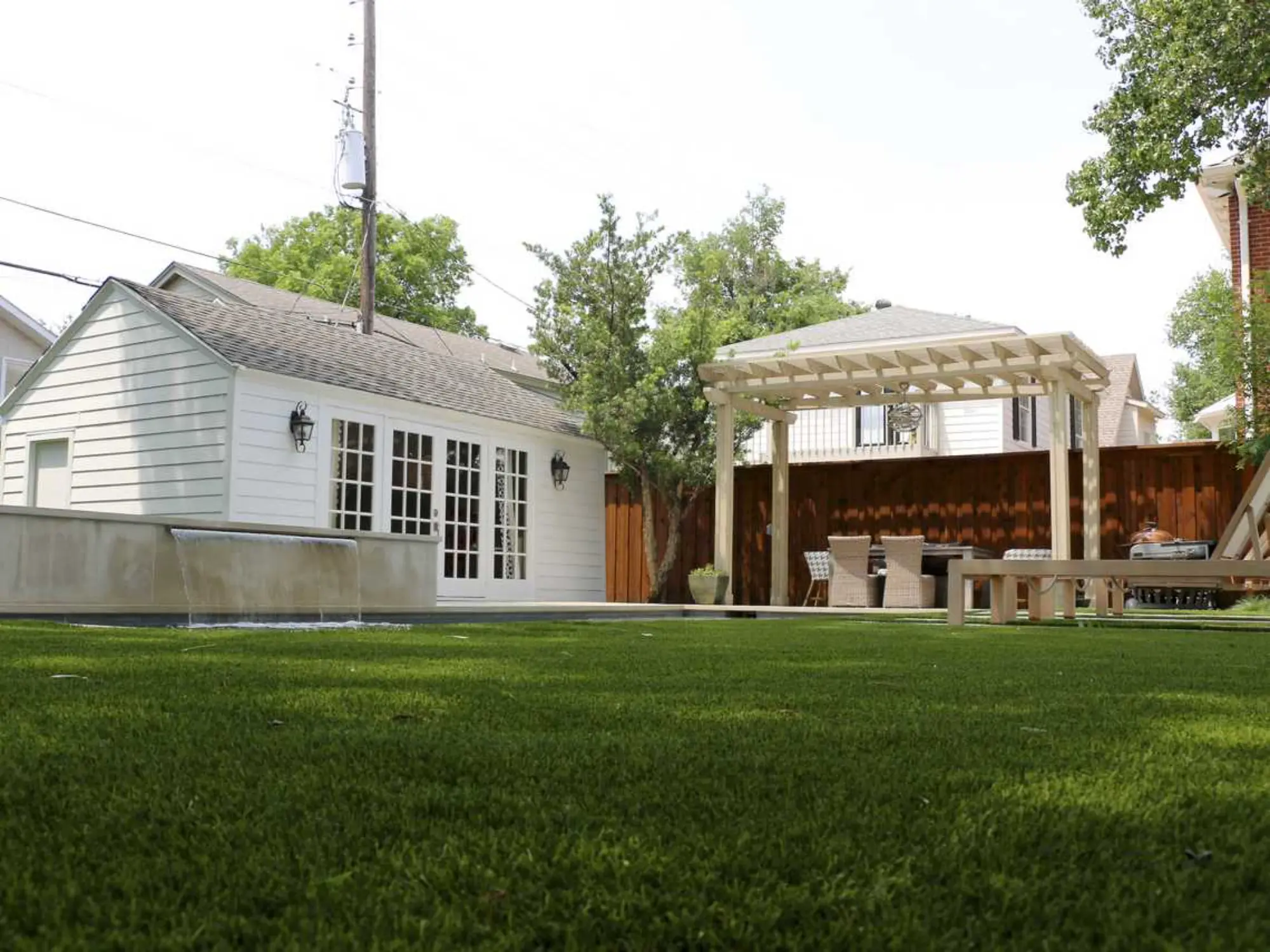 A vibrant backyard with a sparkling pool and a rustic wooden fence, creating a serene outdoor retreat.