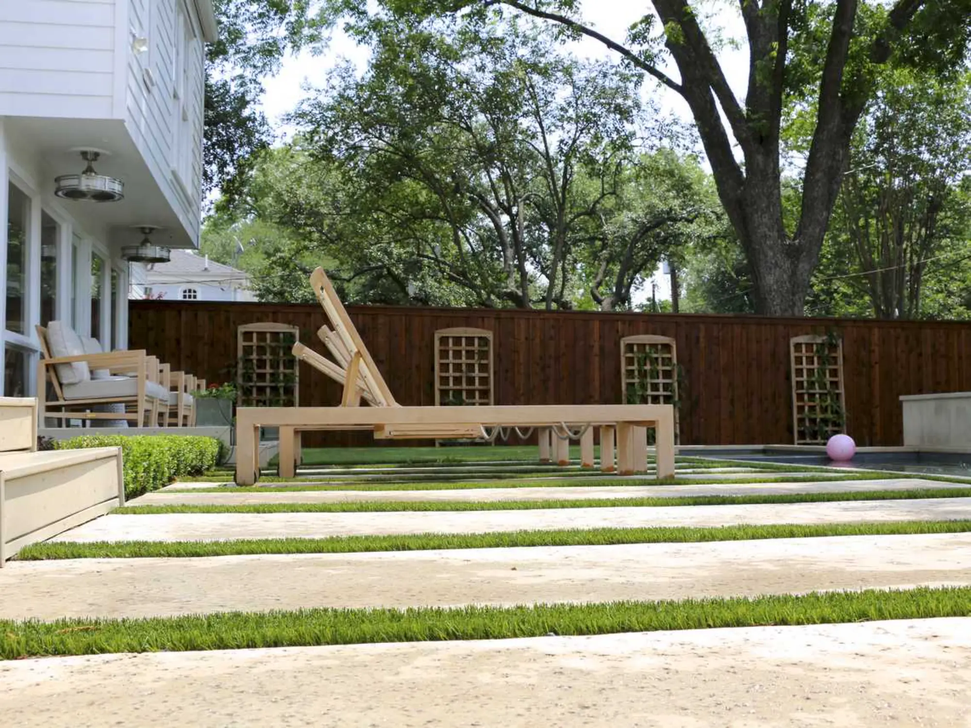  A serene backyard featuring a wooden bench surrounded by lush green grass.