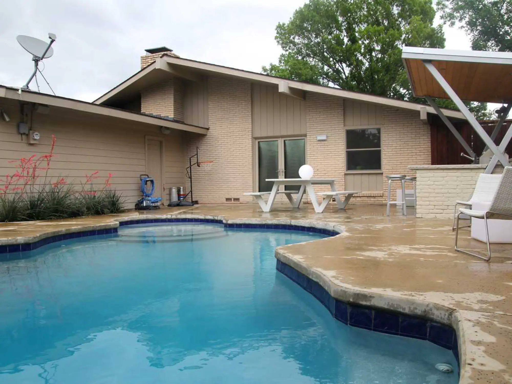 A backyard pool surrounded by a table and chairs, perfect for relaxation and outdoor gatherings.