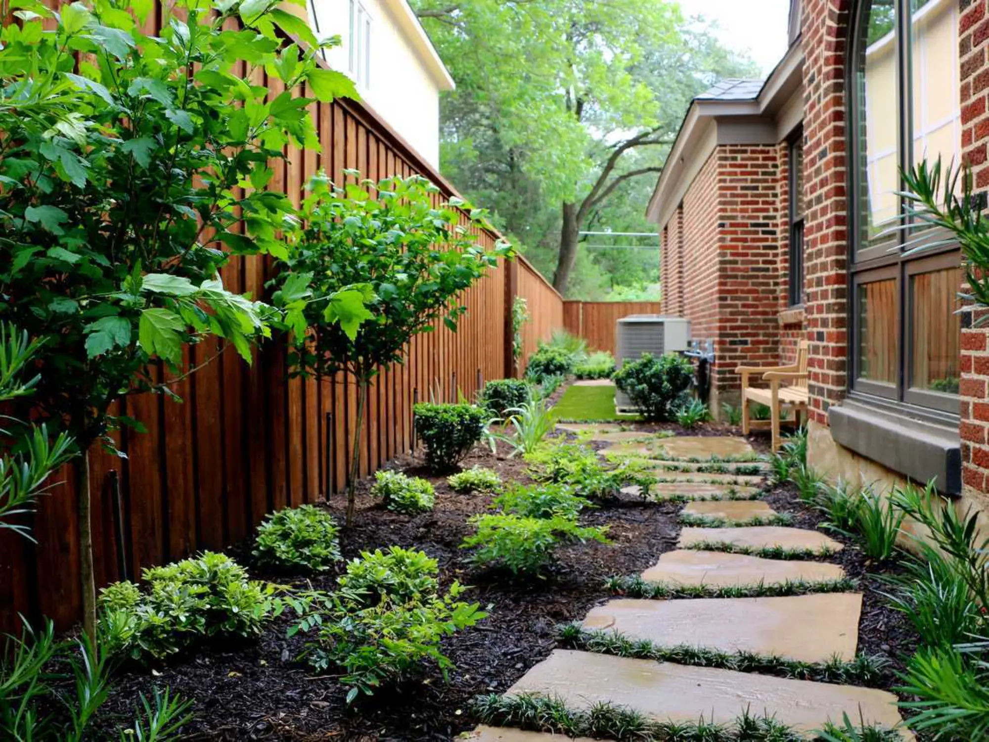 A peaceful garden scene with a stone path winding through vibrant plants, leading to a welcoming bench.