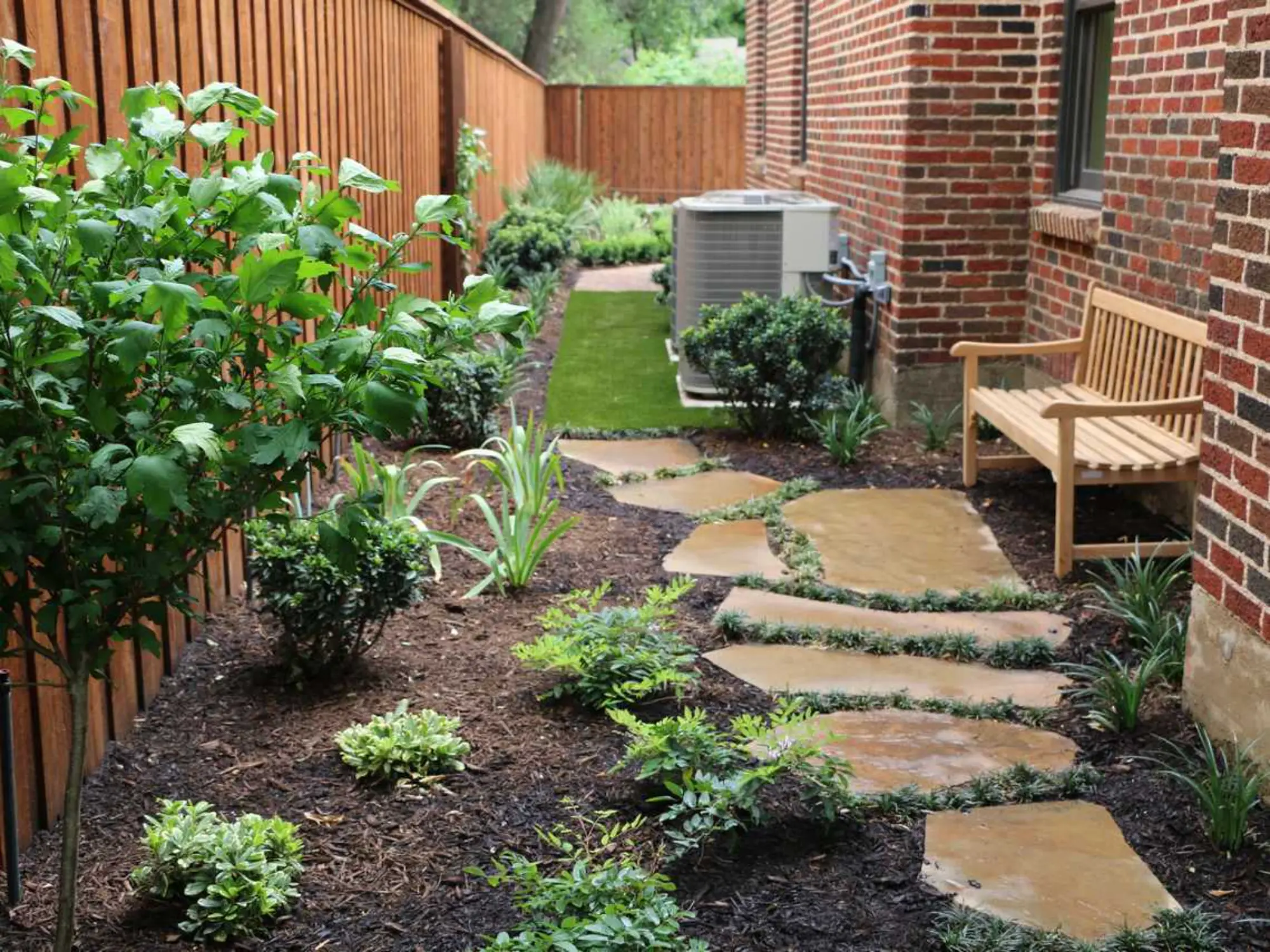A tranquil garden scene with a stone path winding through vibrant plants, leading to a welcoming bench.
