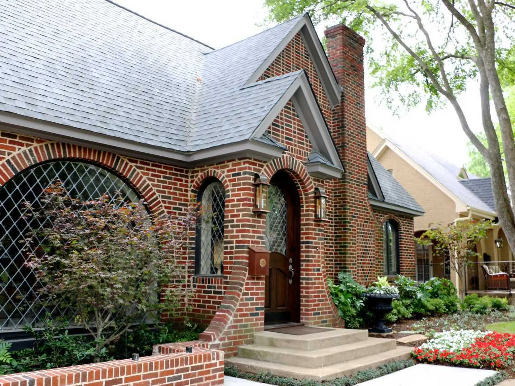 A brick house featuring a window and a decorative brick archway, showcasing classic architectural design.